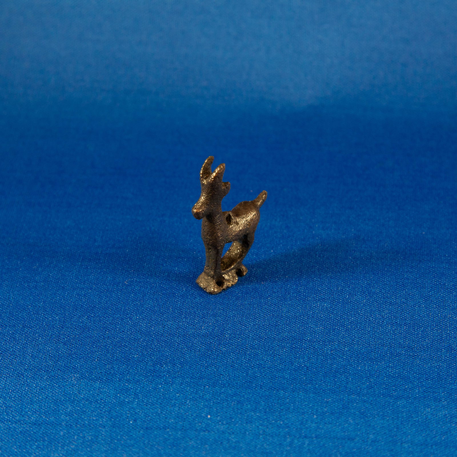 FITTING: YELLOW DEER LURISTAN (1000-500 BC): A charming miniature bronze yellow-deer figurine from the Luristan cultural horizon of early Iron Age western Iran. Cast in solid bronze, the deer stands upright on a small integral base, with stylize
