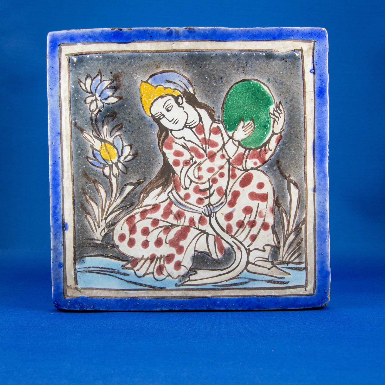 PHOTO ALBUM: ENAMEL AND SILVER QAJAR (1789-1925 CE): The album features finely painted lacquered covers richly decorated with dense floral arabesques in gold, red, and black, centered by oval cartouches depicting architectural and landscape scenes rende