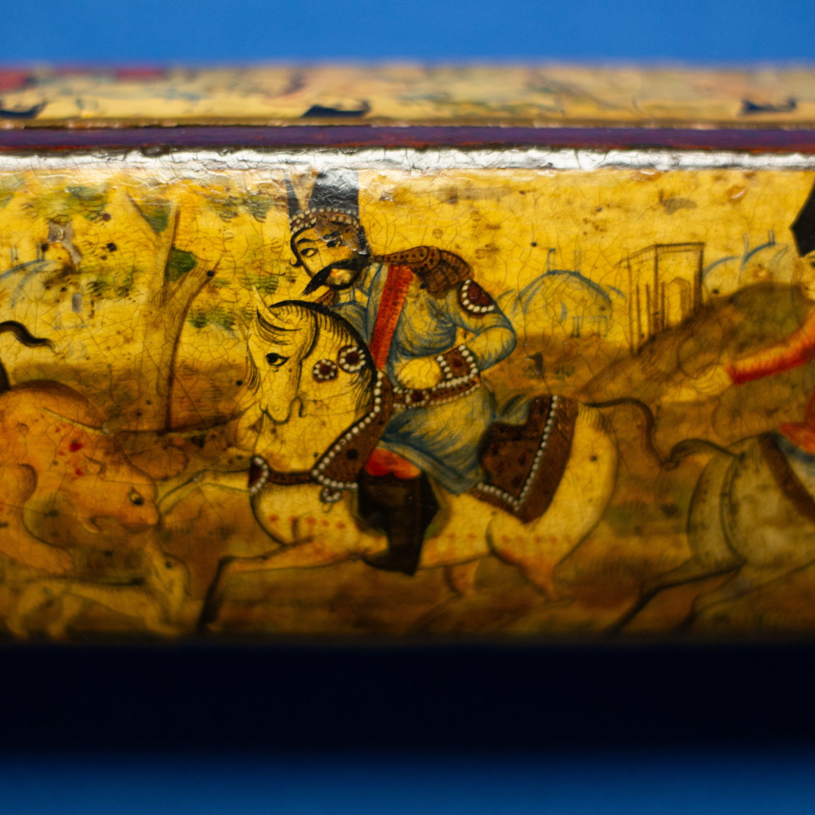 QALAMDAN: LARGE ROYAL PORTRAITURE QAJAR (1789-1925 CE): This lacquered case from the Qajar period, with a body made of light wood and a lacquered surface, represents the court of Nasser al-Din Shah. The painting on the curved surface of the pen case depict