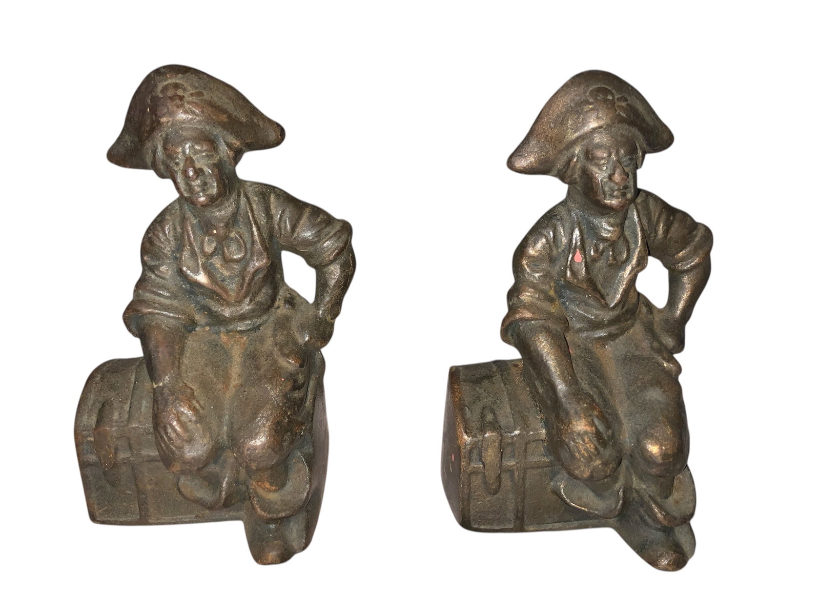 Two Cast Iron Bookends Pirate Figure Sitting on a Treasure Chest: Good condition with no chips, cracks, breaks, or repairs. Appear to have once had a golden shiny finish which has largely been worn away.6” tall 3’x4” each, 8lb total