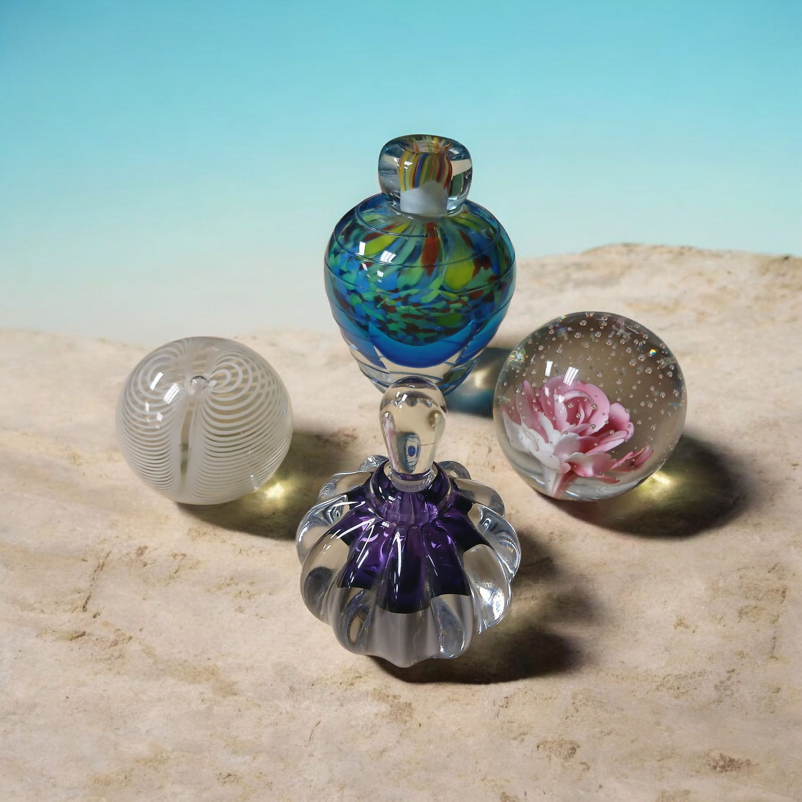 Collection is 2 Paperweights and 2 Perfume Bottles: Collection is 2 Paperweights and 2 Perfume Bottles Paperweight with weight swirl is signed on bottom Clear and purple Perfume bottle is signed and numbered..================================= PLEASE
