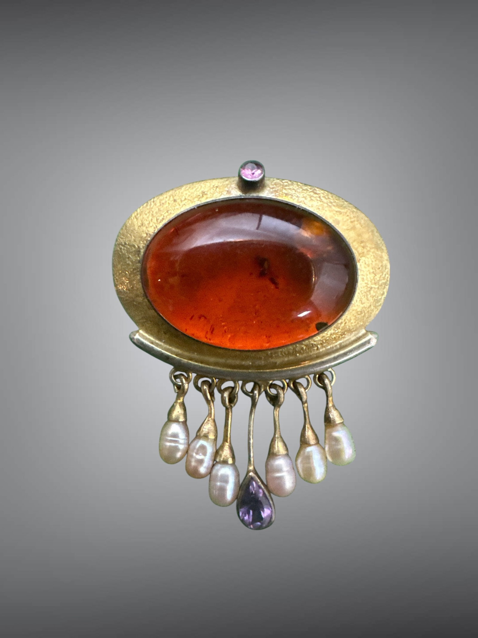Vtg 925 Amber-Pearl-Amethyst Brooch / Pendant: Vtg 925 Amber-Pearl-Amethyst Brooch / Pendant. Large central stone appears to be amber with inclusions. There is one feature at 1:00 that may be a bubble, or inclusion, or a bruise. It is smooth to th