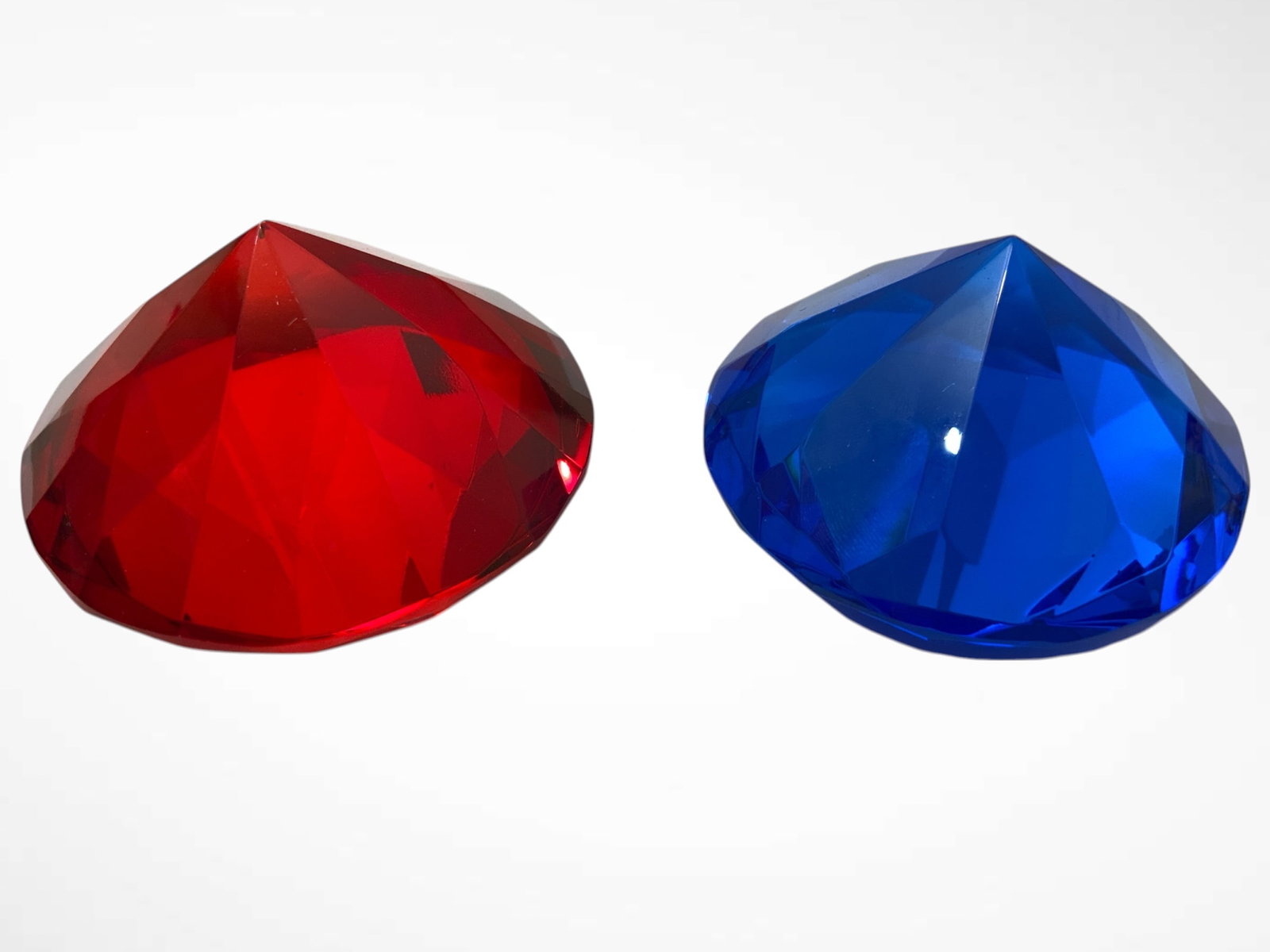 Paperweights Red and Blue Diamond-shape: Paperweights Red and Blue Diamond-shape. Faceting differs between the two pieces. Red is an applied color and a small area at the peak has come off. Blue has no defects on visual inspection. Each is