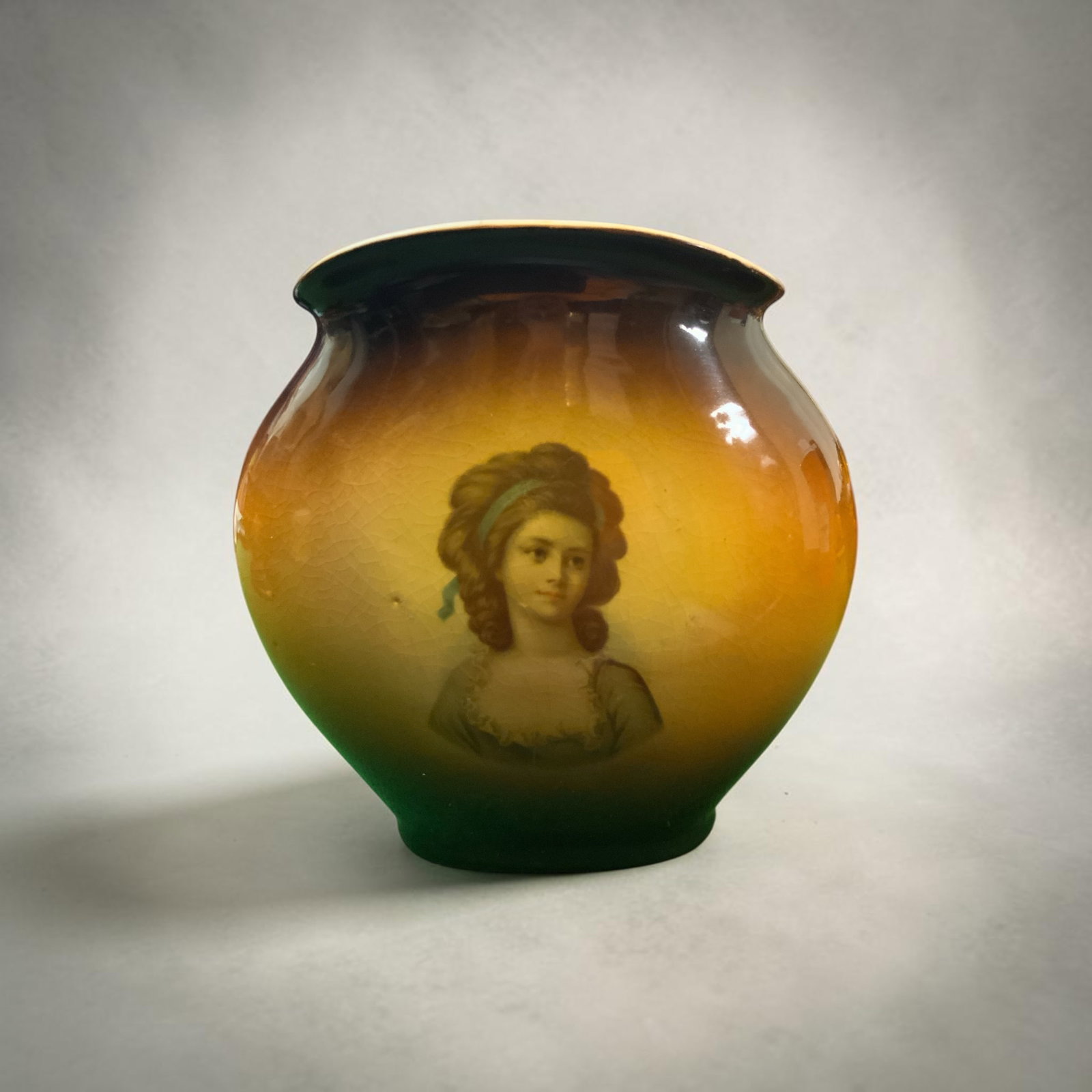 Handpainted Portrait Vase IOGA Ware Warwick China: Handpainted Portrait Vase IOGA Ware Warwick China. Glaze has significant crazing. There are a number of white specks in the amber 'belt' on the reverse side. Defect in the front appears to be original