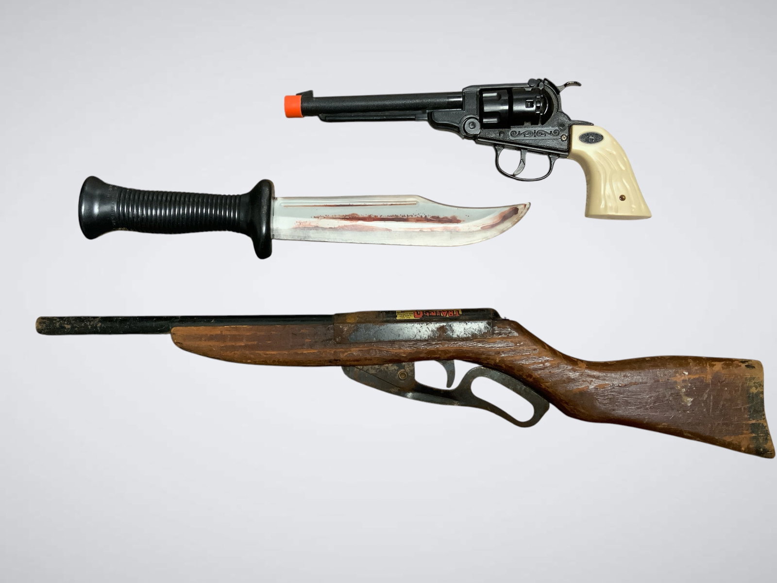Vintage Toy Weapons Lot Featuring Parris Mfg Co Trainer Rifle: Vintage Toy Weapons Lot Featuring Parris Mfg Co Trainer Rifle.Plastic revolver Cap gun, Plastic knife with fake blood 'decor', TraineRifle with wood stock and metal barrel. Rifle is 21 1/2" long. .>>>