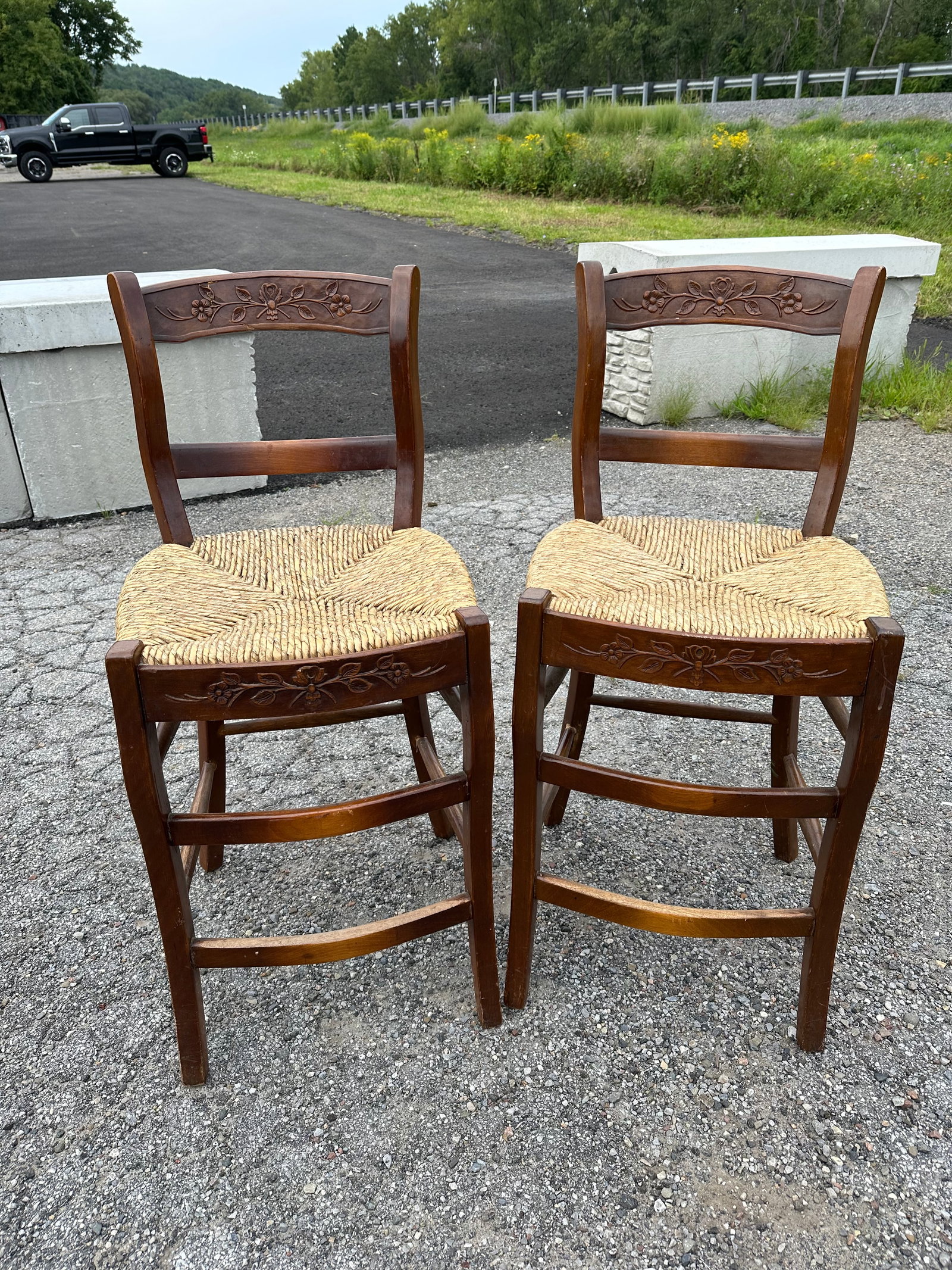 Pair Rush Seat Counter-height Bar Chairs: Pair Rush Seat Counter-height Bar Chairs. Carved floral details on the backrests and aprons. Seats are in excellent condition. One chair has a repair to the crest. Looks and feels secure. 38”tal