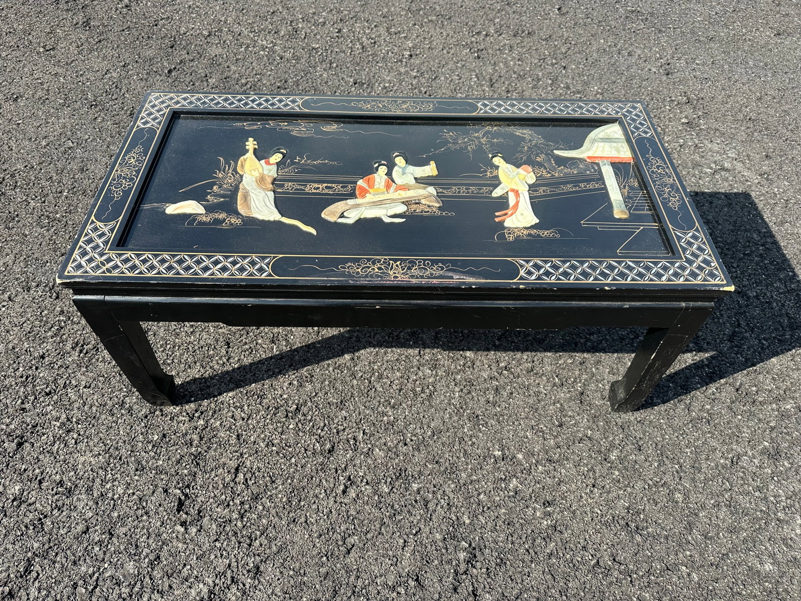 Vintage Black Lacquered Asian Coffee Table Mother of Pearl “Royal Ladies” with Glass Overlay: Vintage Black Lacquered Asian Coffee Table Mother of Pearl “Royal Ladies” with Glass Overlay Top. Shows some wear on the corners and edges consistent with age. 15”tall x 36”wide x 