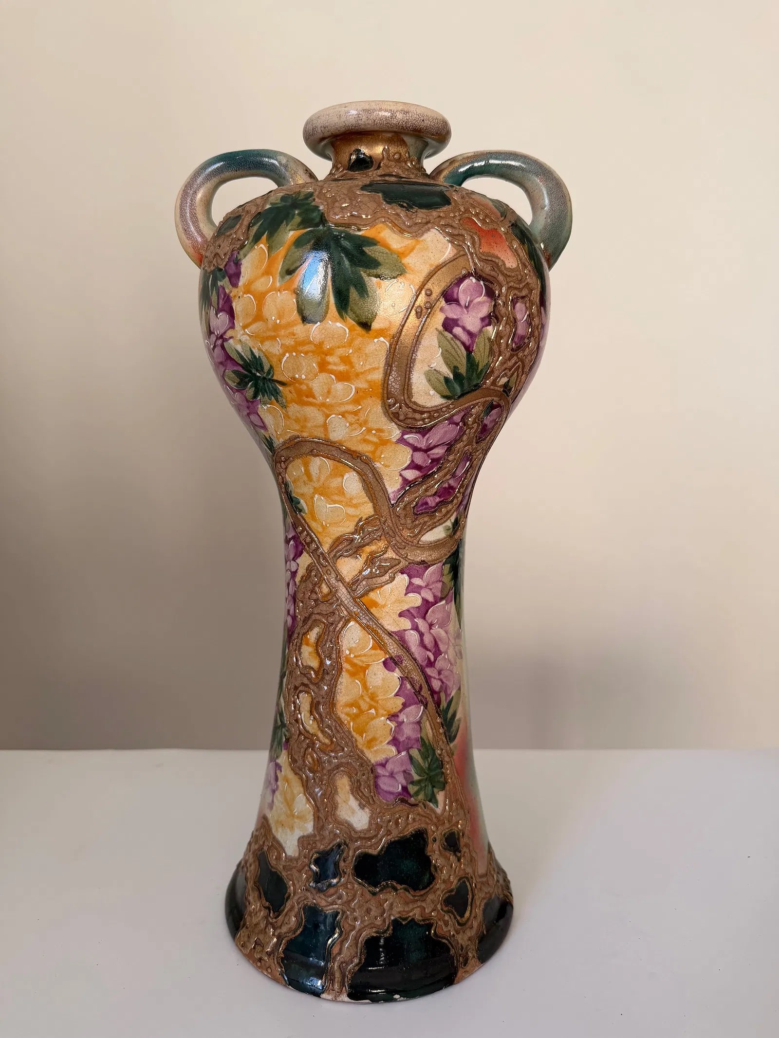 Polychrome relief-decorated pottery vase with floral motifs and twin handles (1 of 3)