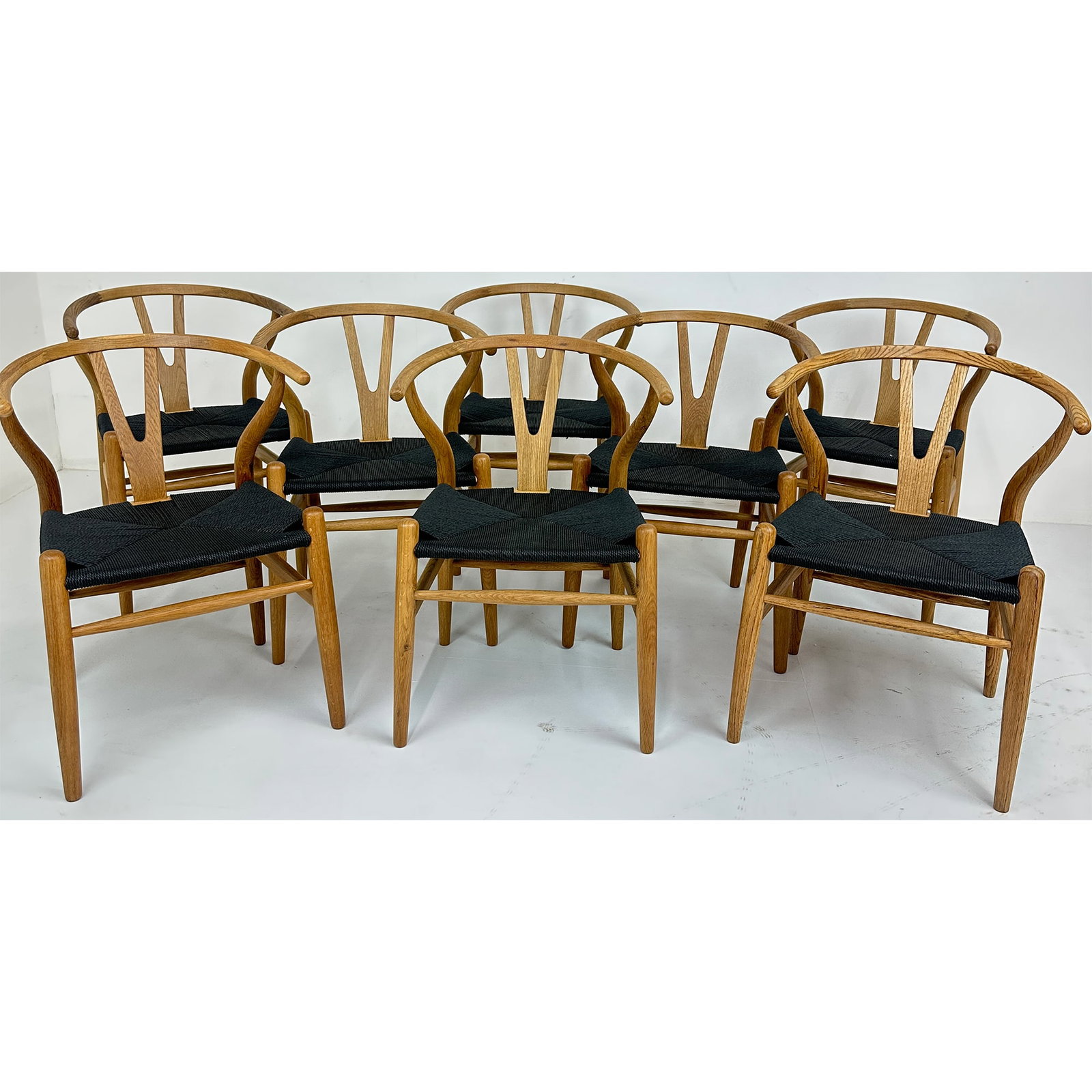 Set of 8 Wish Danish Style Dining Chairs: The Wish Dining Chairs showcase classic mid-century Danish-inspired design with their signature curved wooden frames and woven black seats. Crafted for both comfort and visual appeal, these chairs