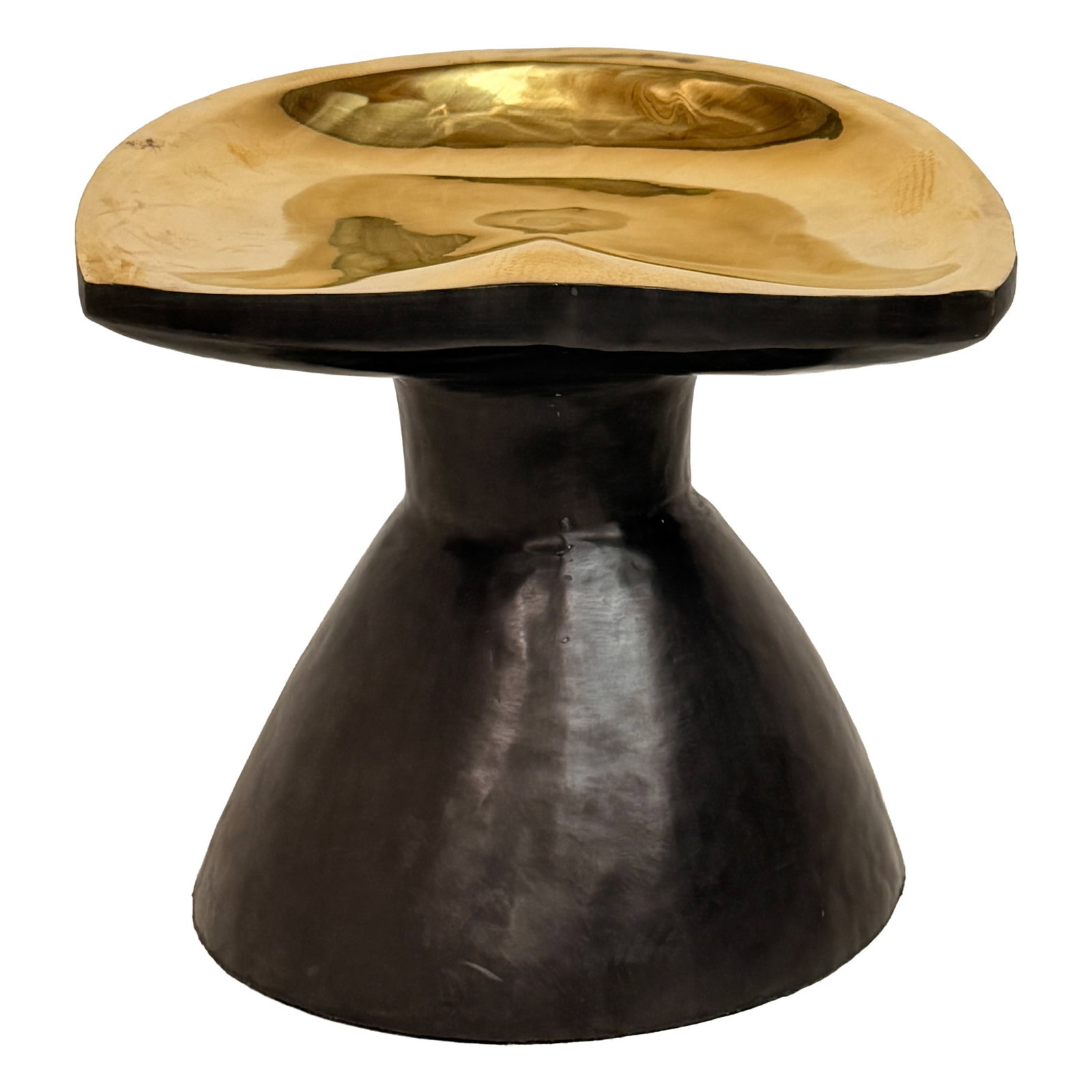 Sculptural Brass Accent Stool: Distinctive sculptural accent stool or side table featuring a polished brass-tone top with an organic, gently concave form set above a contrasting dark flared pedestal base. The dramatic two-tone