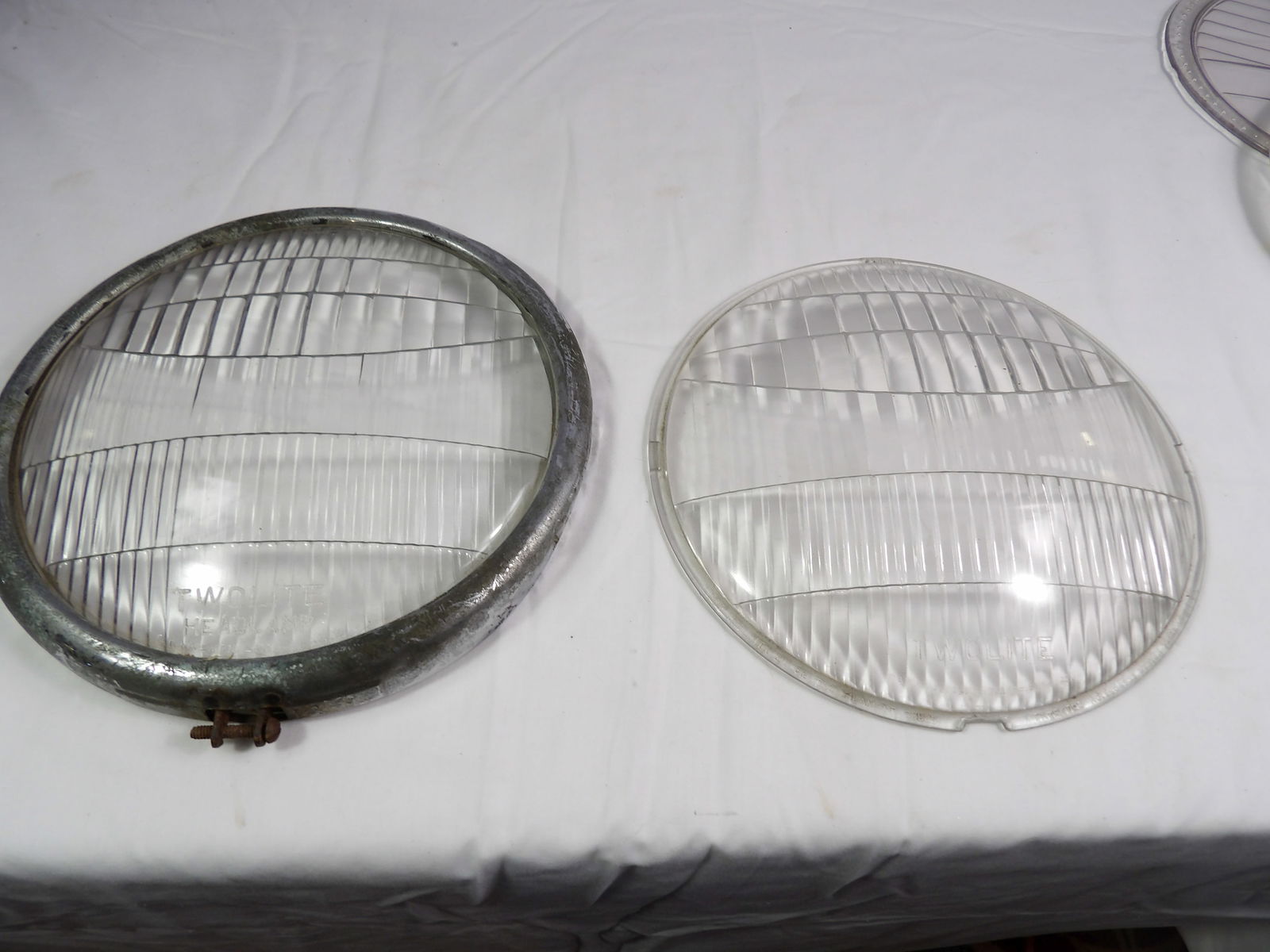 Pair of Bowed Glass Twolite Headlamp Lenses: Pair of Bowed Glass TwoLite Headlamp Lenses 9 7/16 x 8 15/16. All measurements approximate. Please see photos for condition and details. Selling as is from 04281.