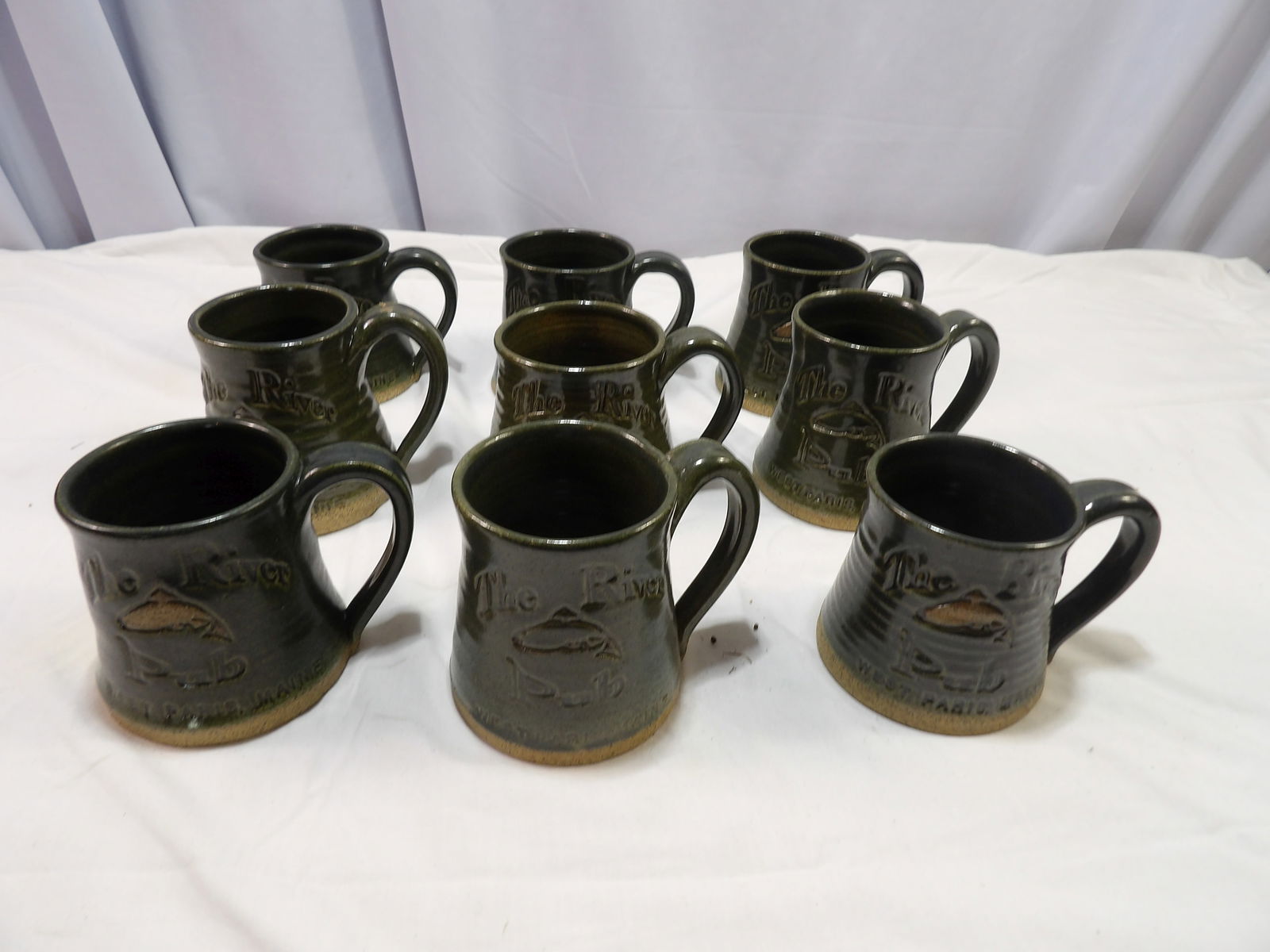 9 PCS-Custom Made Pottery Mugs: 9 Custom Made Pottery Mugs, "The River Pub" , West Paris, ME. All measurements are approximate. Please see photos for condition and details. Selling as is from 04281.