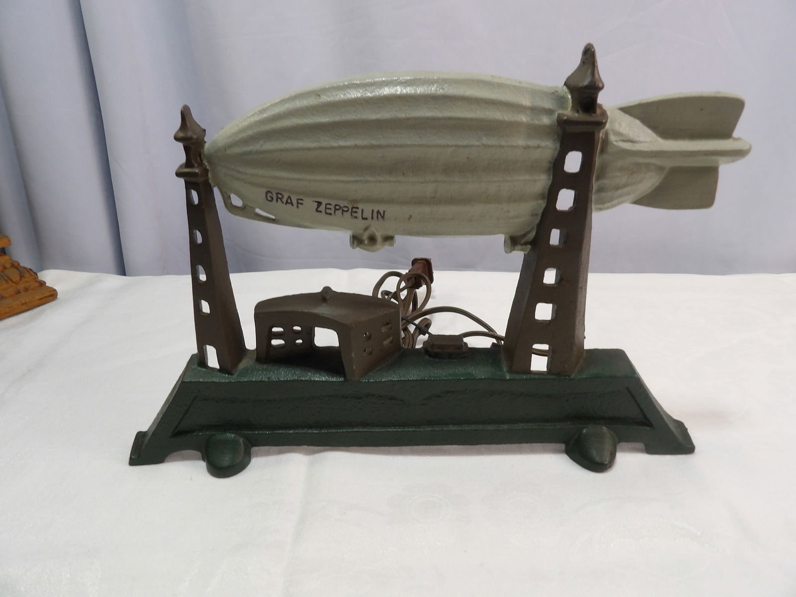 Cast Iron Lamp: 12" Graf Zeppelin Cast Iron Lamp, Marked "Schylling". All measurements approximate. Please see photos for condition and details. Selling as is from 04281.