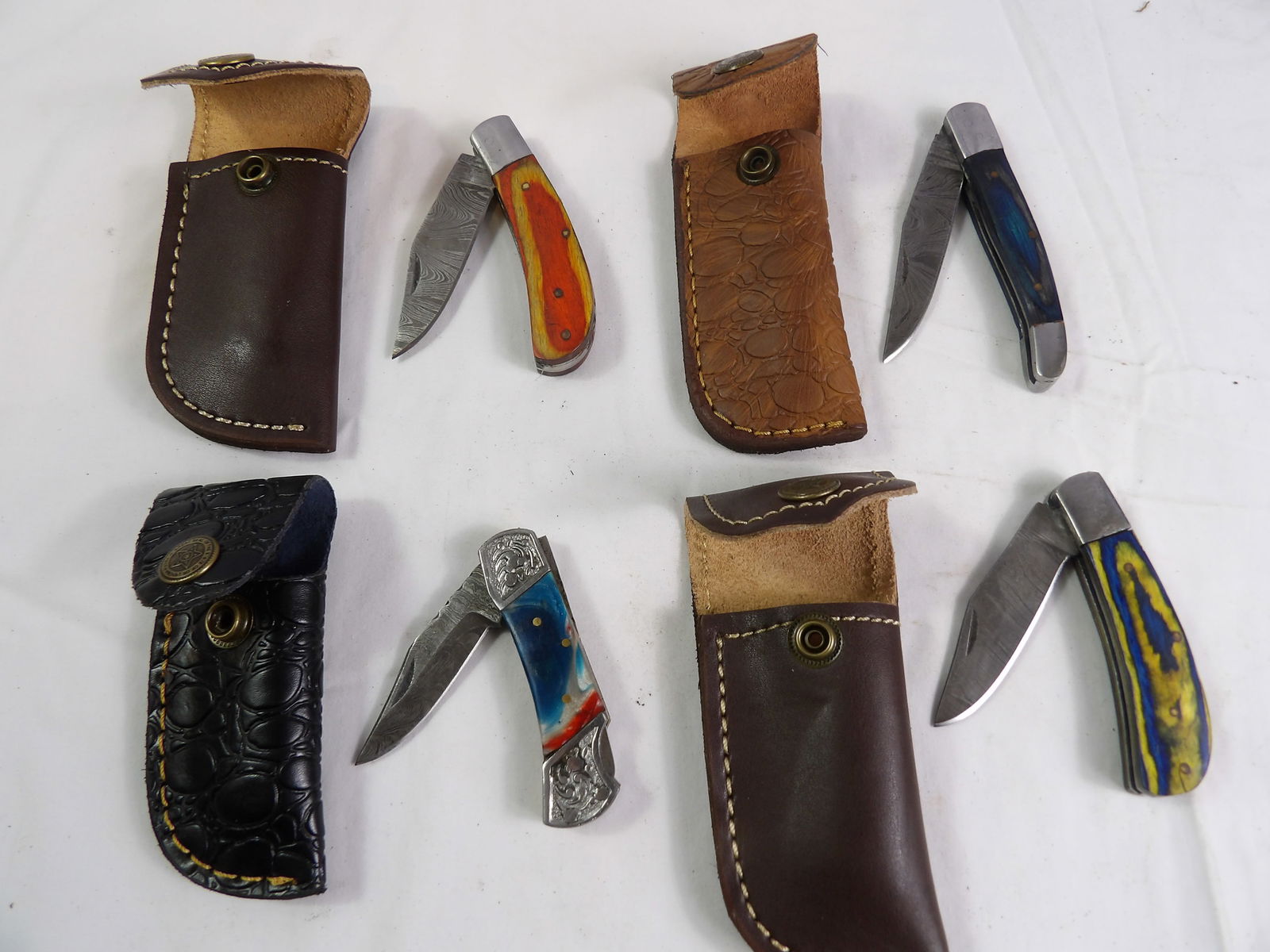 4 PCS MHS Cutlery: 4 Piece MHS Cutlery Hand Forged Damascus Blade Folding Pocket knives with Leather Sheaths. All measurements approximate. Please see photos for condition and details. Selling as is from 04281.
