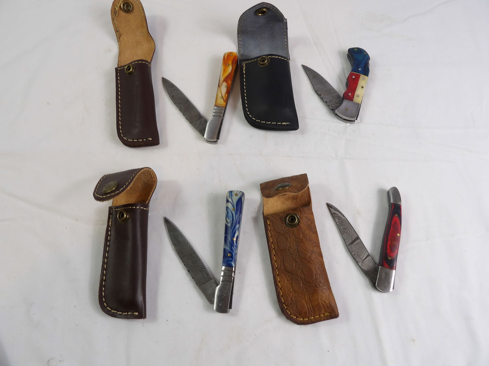 4 PCS MHS Cutlery: 4 Pieces MHS Cutlery Hand Forged Damascus Steel Folding Knives with Leather Sheaths. All measurements approximate. Please see photos for condition and details. Selling as is from 04281.