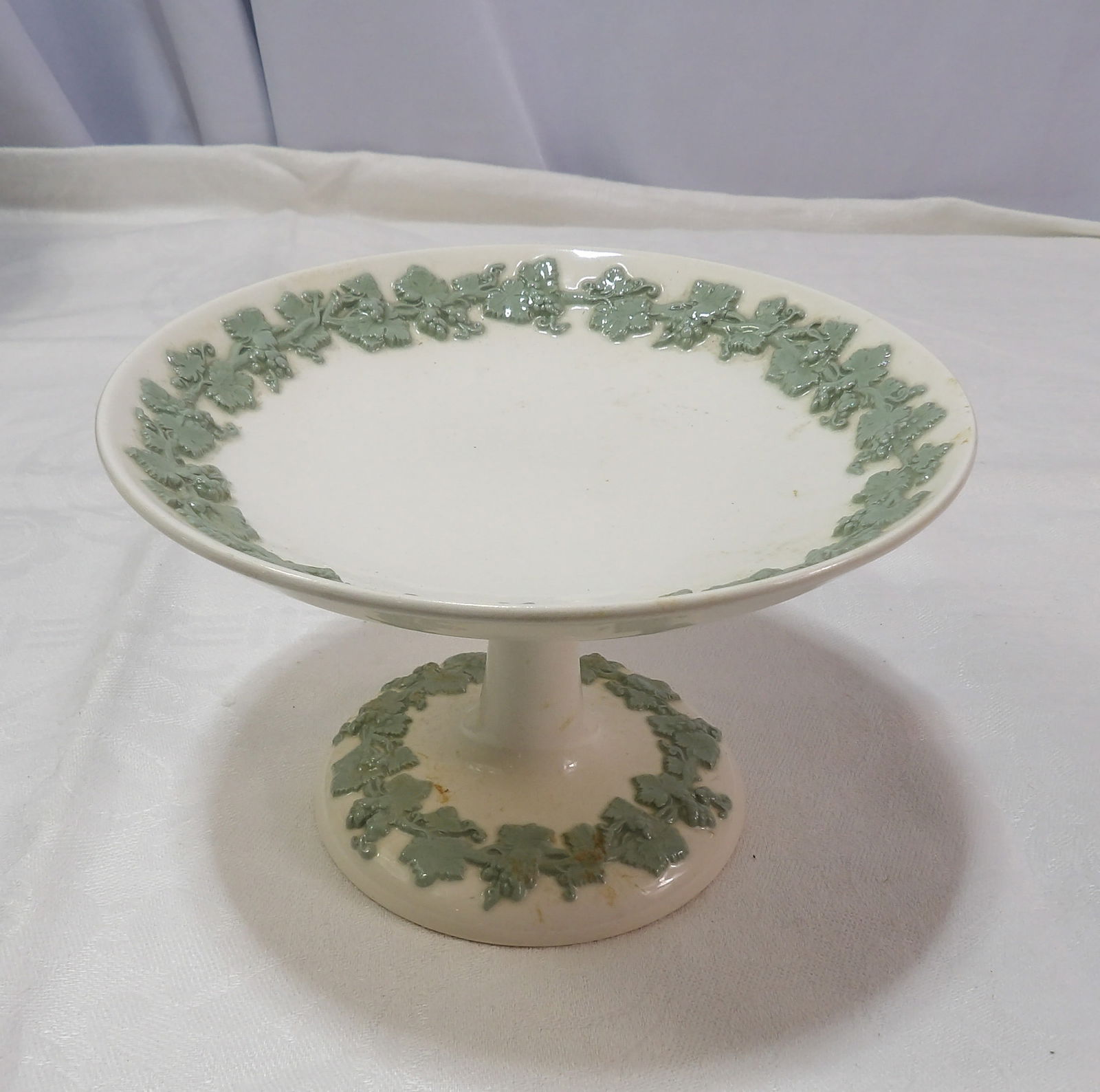 Footed Dessert Plate: Wedgewood Queensware Celadon on Cream Color Footed Dessert Plate. All measurements approximate. Please see photos for condition and details. Selling as is from 04281.