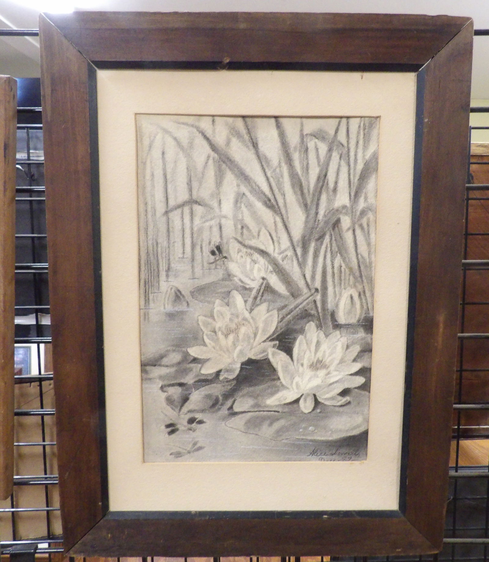 Framed and Signed Charcoal Drawing: Framed Water Lily Charcoal Drawing. Signed. 15" x 21" All measurements approximate. Please see photos for condition and details. Selling as is from 04281.