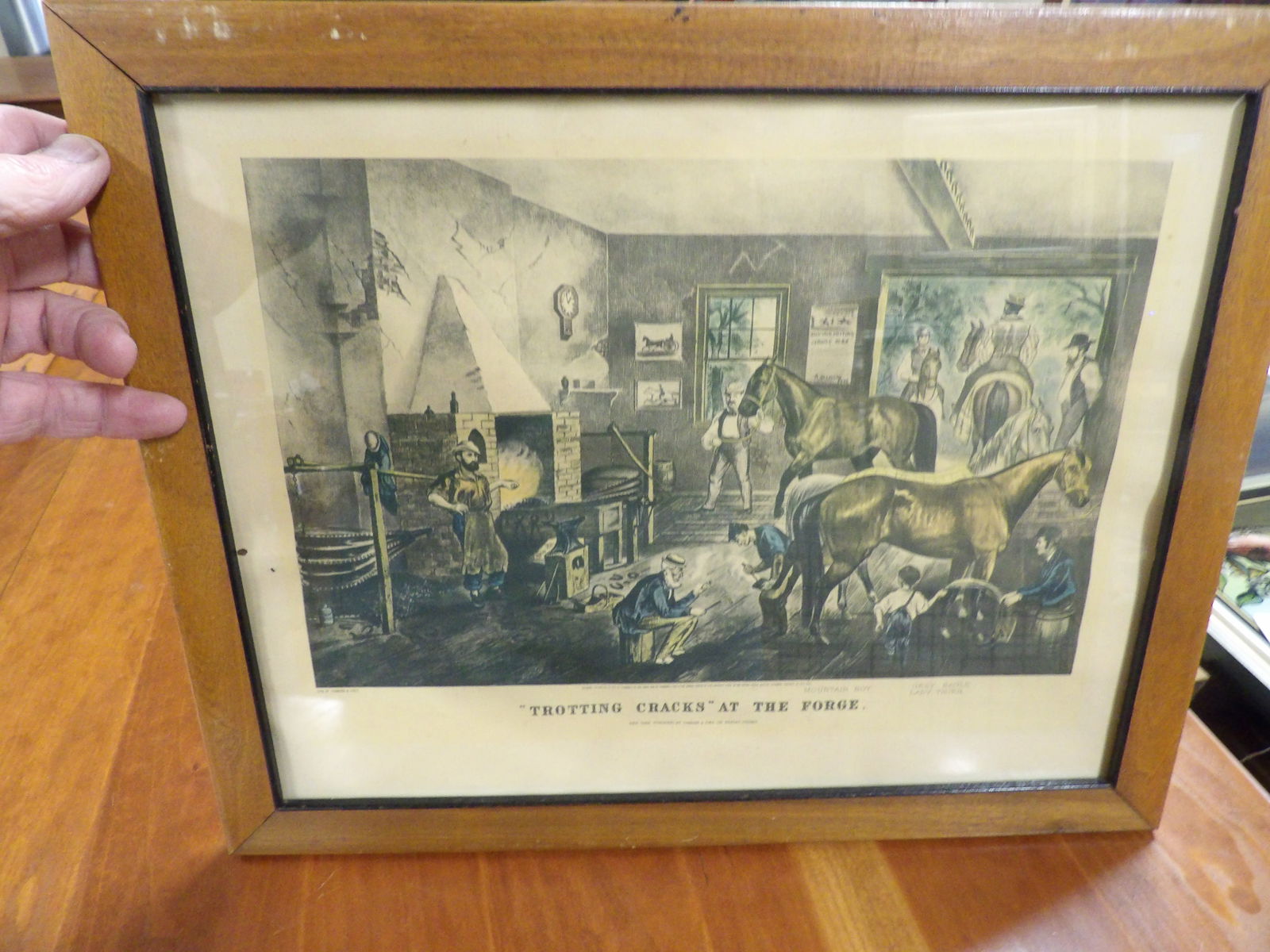 Currier and Ives Print: Currier and Ives "Trotting Cracks at the Forge" Print. 12" X 16". All measurements approximate. Please see photos for condition and details. Selling as is from 04281.