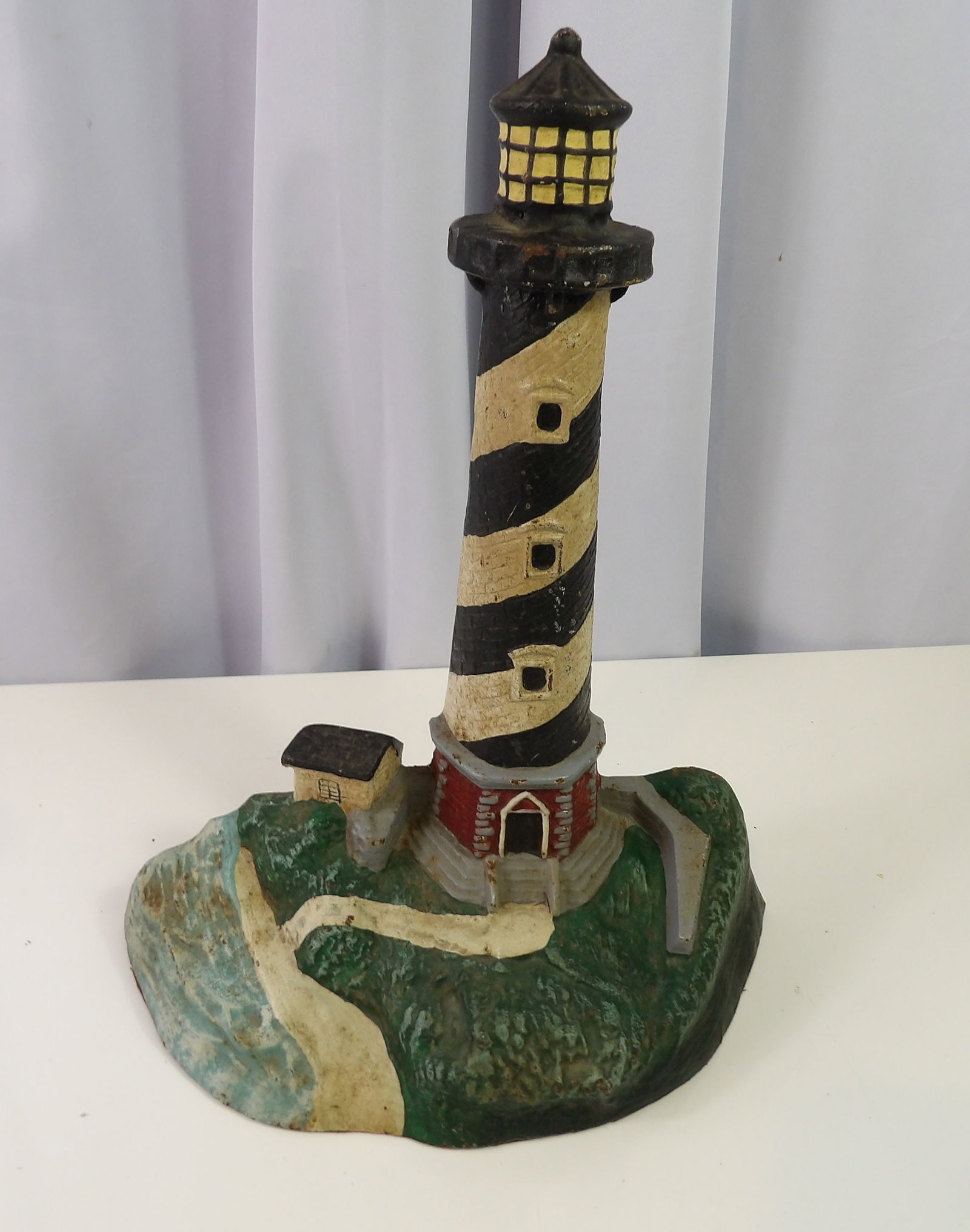 Cast Iron Lighthouse Sculpture: 13 1/2" Cast Iron Lighthouse Sculpture with Coastal Base. All measurements approximate. Please see photos for condition and details. Selling as is from 04281.