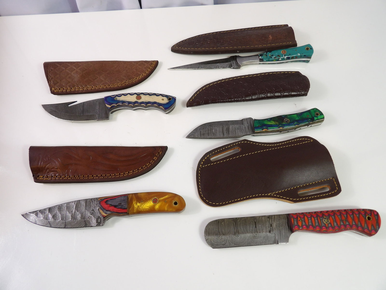 5 Handmade Damascus Steel Knives With Sheaths: Lot of 5 New Handmade Damascus Steel Knives with Leather Sheaths. All measurements approximate. Please see photos for condition and details. Selling as is from 04281.