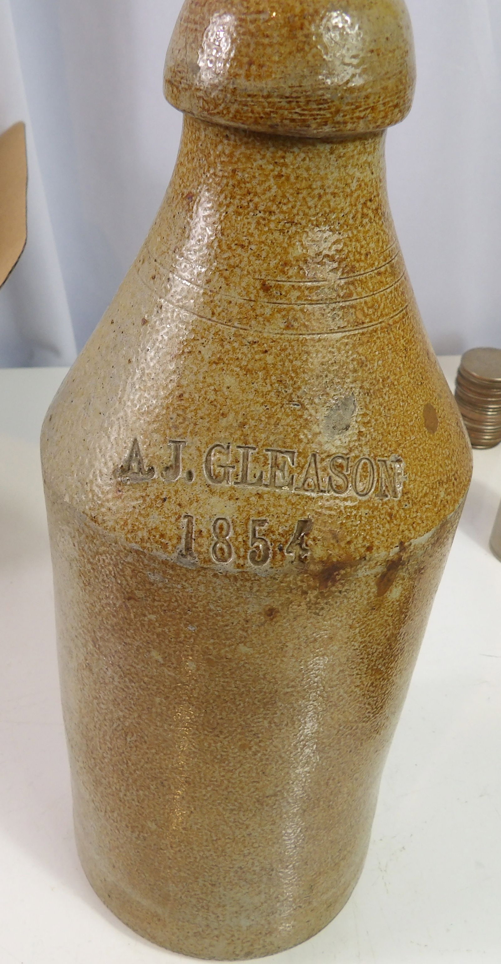 1854 A.J. Gleason Stoneware Beer Bottle: A.J. Gleason, 1854, Stoneware Beer Bottle. Excellent Condition. All measurements approximate. Please see photos for condition and details. Selling as is from 04281.