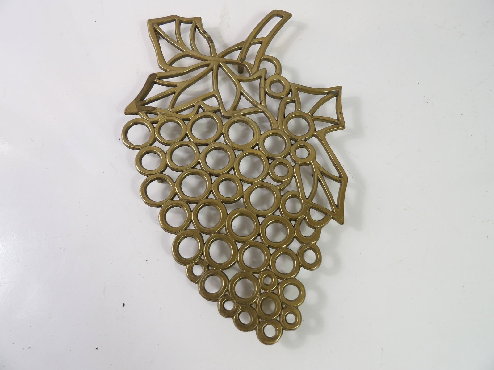 Large Vintage Brass Grape Trivet: Large Vintage Brass Grape Trivet. All measurements approximate. Please see photos for condition and details. Selling as is from 04281.