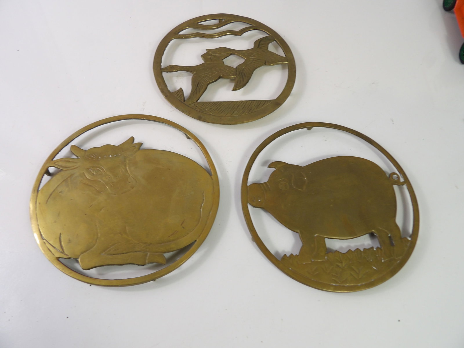 3 PCS.- Vintage Brass Trivets: Lot of 3 Vintage Brass Trivets. Geese, Cow, and Pig. All 7" Diameter. All measurements approximate. Please see photos for condition and details. Selling as is from 04281.