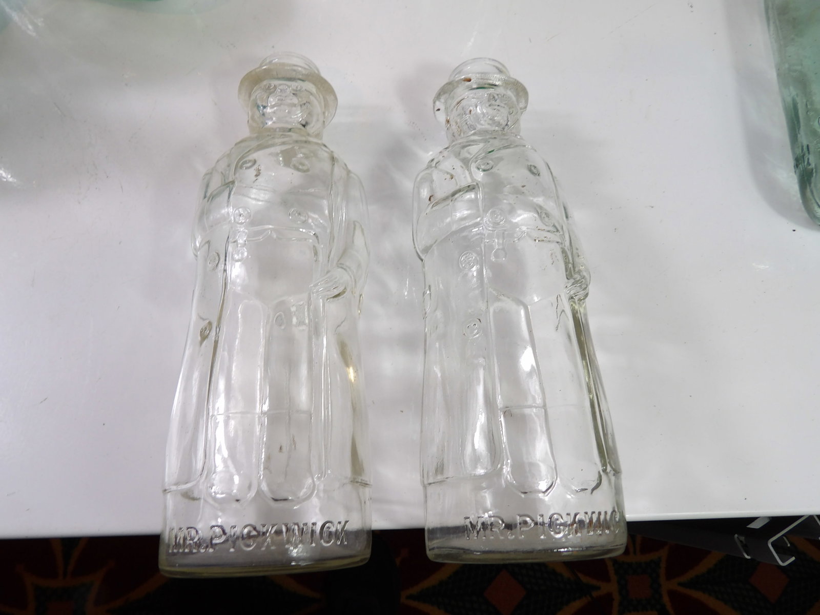 Pair of Early Mr. Pickwick Glass Bottles: Pair of Early Mr. Pickwick Clear Glass Bottles. All measurements approximate. Please see photos for condition and details. Selling as is from 04281.