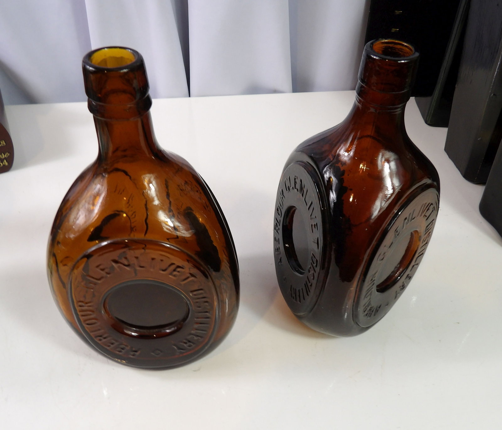Pair of W.H. Holt & Sons Glenlivet Distillery Bottles: Pair of W.H. Holt & Sons Glenlivet Distillery Bottles, Triangle Shaped, Very Rare. All measurements approximate. Please see photos for condition and details. Selling as is from 04281.