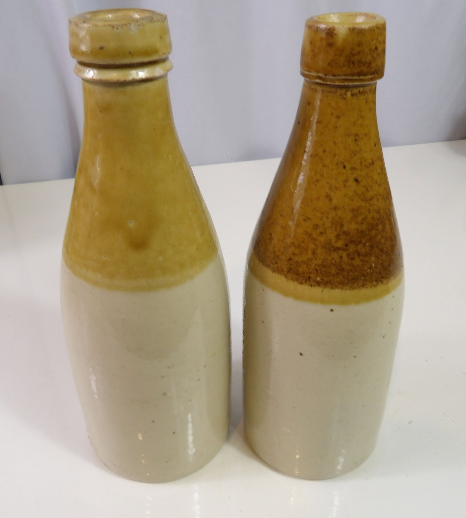 Pair of Two Tone Stoneware Ginger Beer Bottles: Pair of Early Two-Tone Stoneware Ginger Beer Bottles. All measurements approximate. Please see photos for condition and details. Selling as is from 04281.