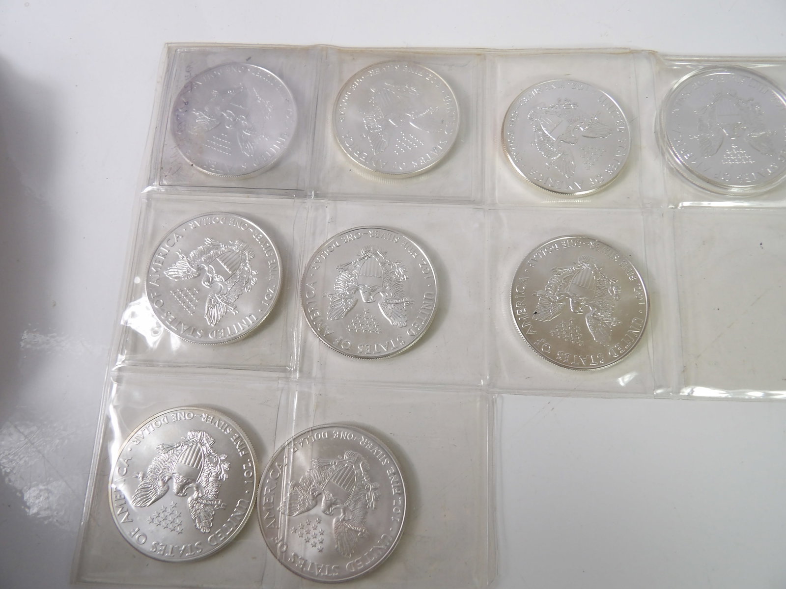 9 Silver Eagles, 1997, 2006, 2011, & 2012: 9 Silver Eagles 1 Oz, .999 Silver 1997, 2006, 2011, and 2012. All measurements approximate. Please see photos for condition and details. Selling as is from 04281.