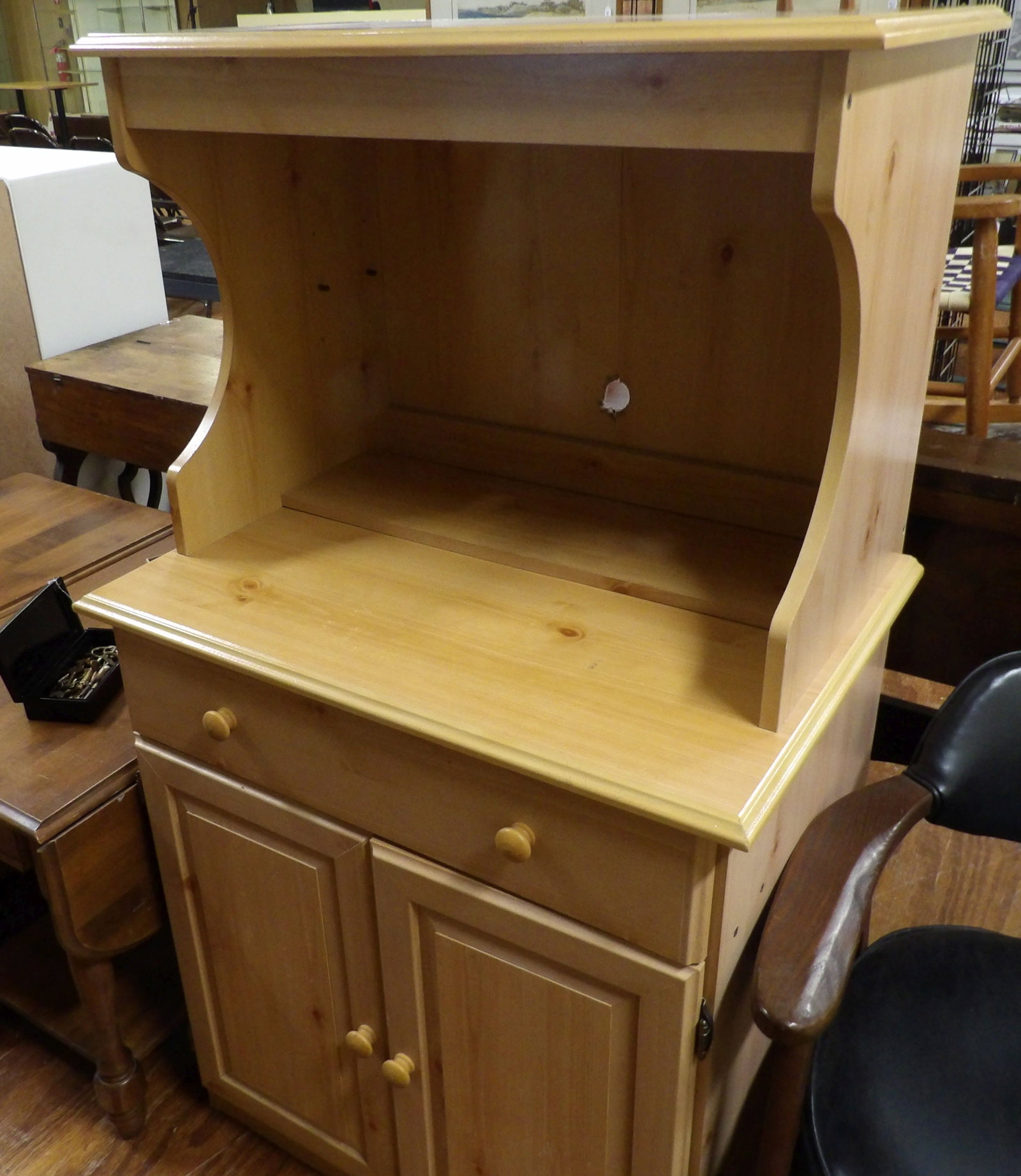Wooden Microwave Stand: Light Toned Wooden Microwave Stand with an Open Shelf and 2 Door Cabinet. All measurements approximate. Please see photos for condition and details. Selling as is from 04281.