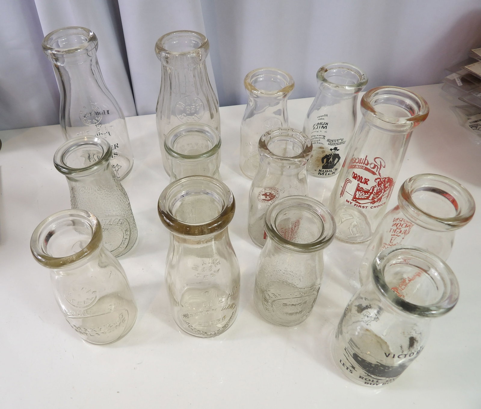 13 PCS.-Early Milk Bottles: Great Lot of 13 Early Milk Bottles. Some Embossed, Some Printed. All measurements approximate. Please see photos for condition and details. Selling as is from 04281.