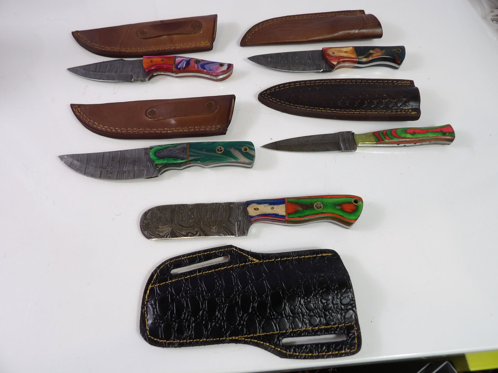 5 Handmade Damascus Steel Knives With Sheaths: Lot of 5 New Handmade Damascus Steel Knives with Leather Sheaths. All measurements approximate. Please see photos for condition and details. Selling as is from 04281.