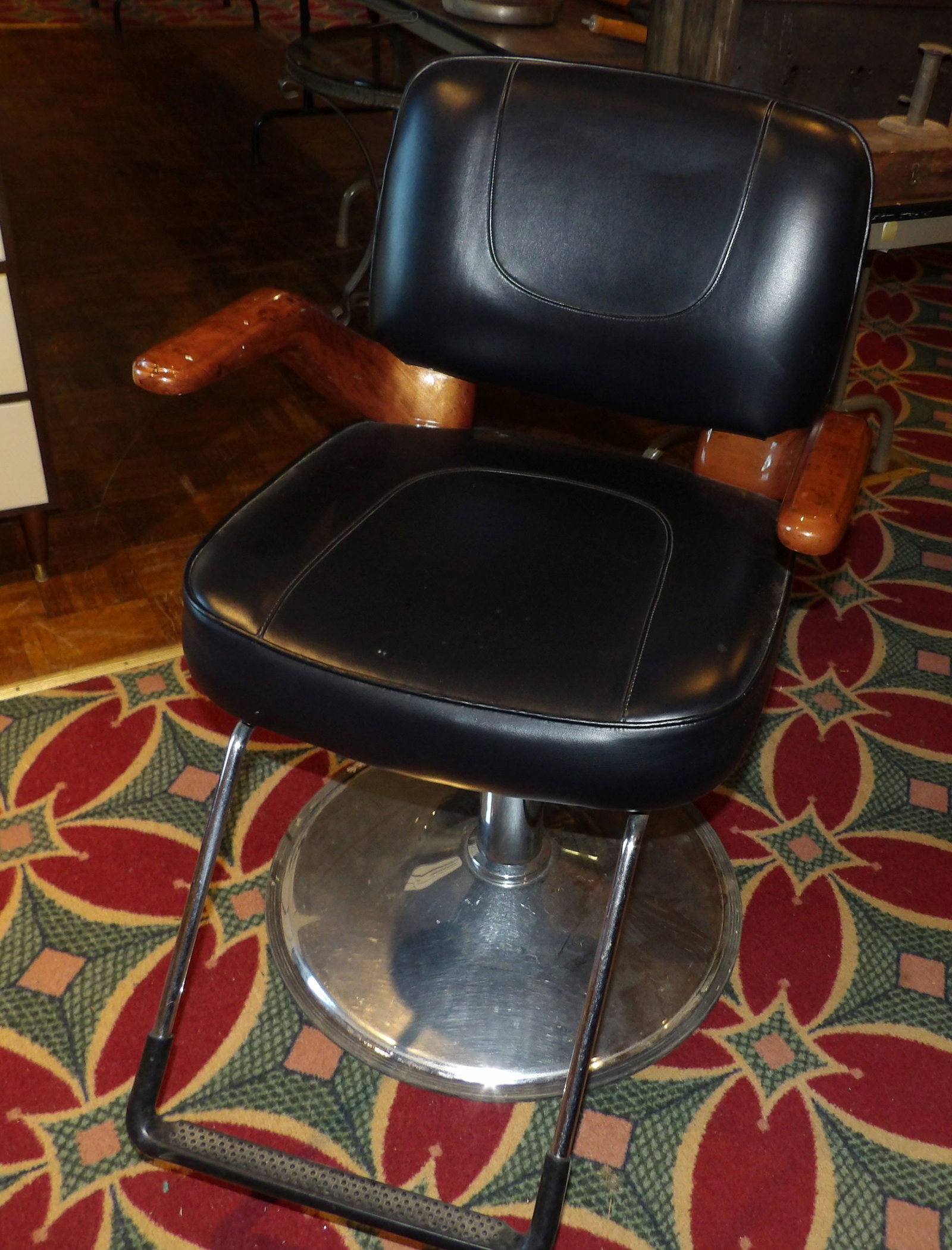 Vintage Black Vinyl Hydraulic Salon Chair, Ascot: Vintage Black Vinyl Hydraulic Salon Chair "Ascot" with Wood Grain Arm Rests . Works as it should. All measurements approximate. Please see photos for condition and details. Selling as is from 04281.