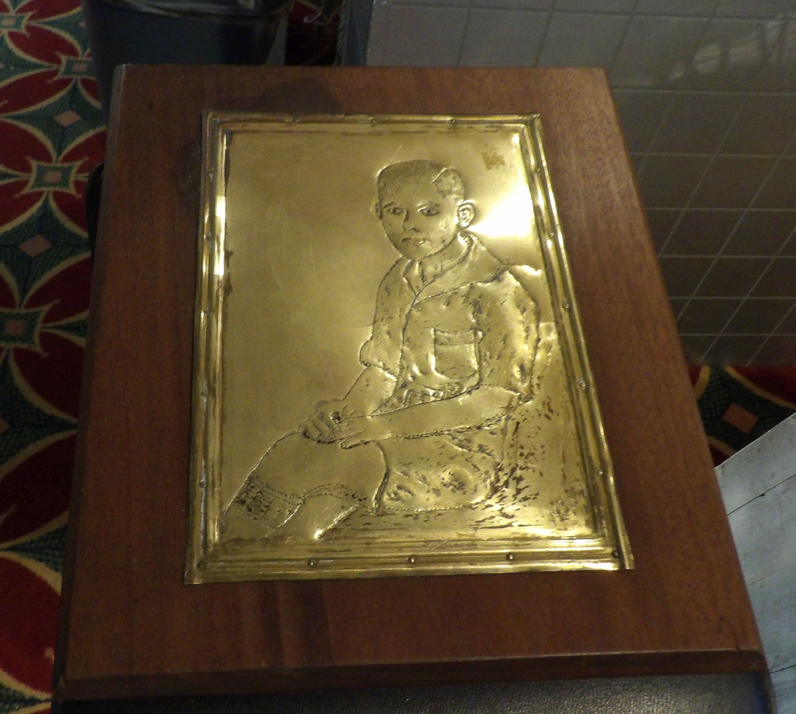 Vintage Brass Bas-Relief Portrait of A Boy: Vintage Brass Bas-Relief Portrait of A Boy on a Wooden Plaque. 14" X 16". All measurements approximate. Please see photos for condition and details. Selling as is from 04281.
