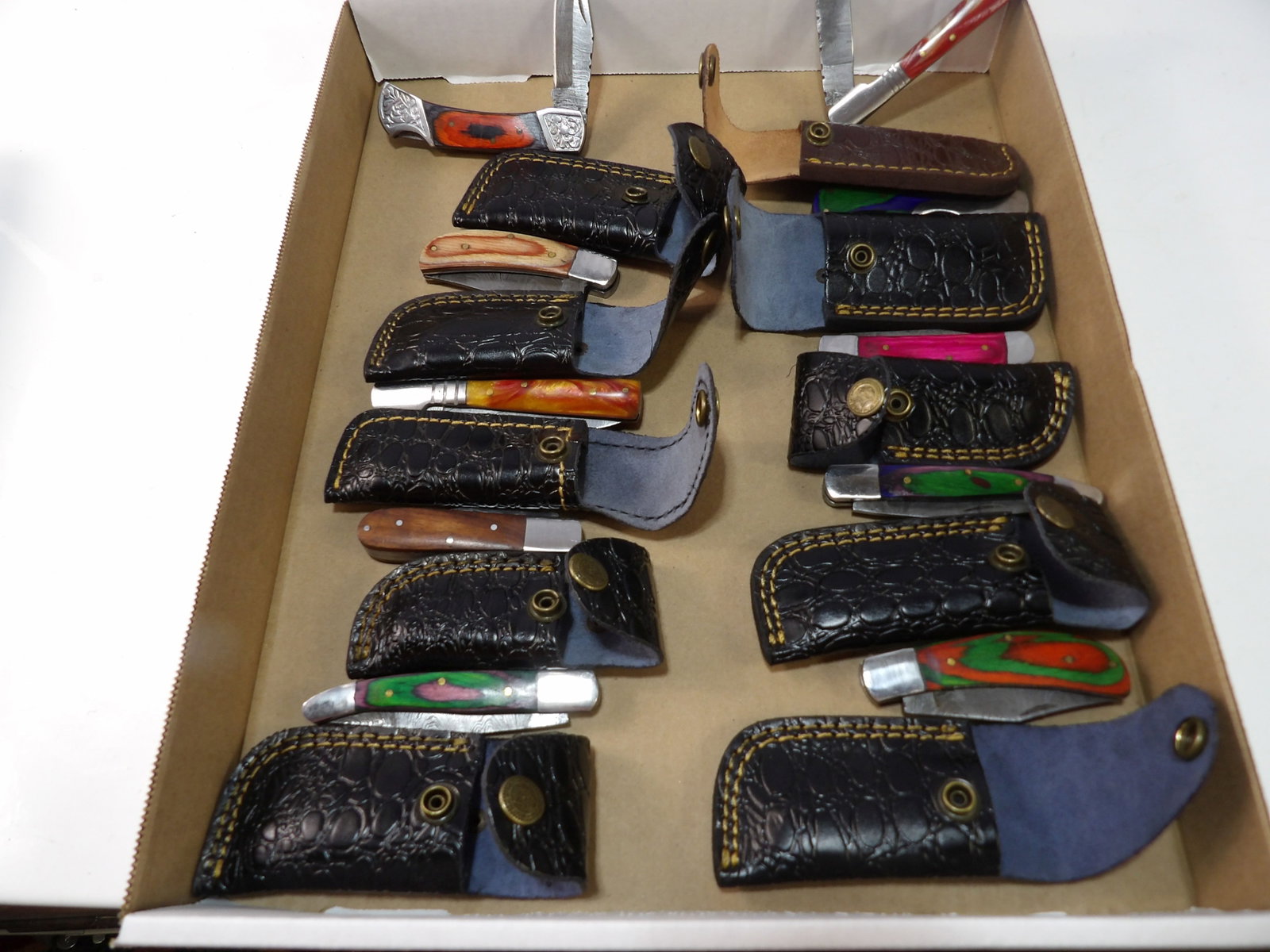 Lot of 10 Handmade Damascus Steel Folding Knives: Lot of 10 New Handmade Damascus Steel Folding Knives with Leather Sheaths. All measurements approximate. Please see photos for condition and details. Selling as is from 04281.