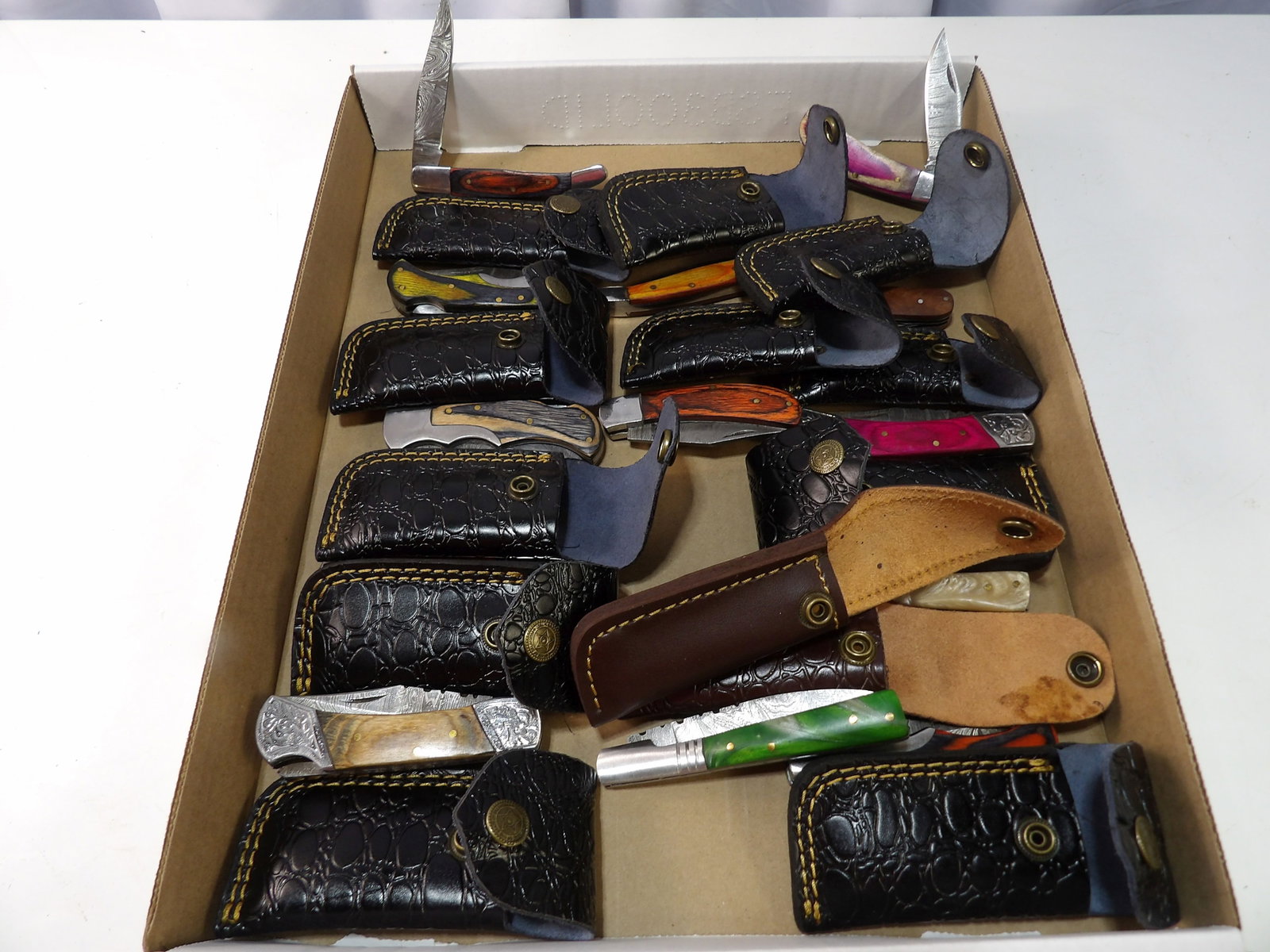 Lot of 13 Handmade Damascus Steel Folding Knives: Lot of 13 New Handmade Damascus Steel Folding Knives with Leather Sheaths. All measurements approximate. Please see photos for condition and details. Selling as is from 04281.