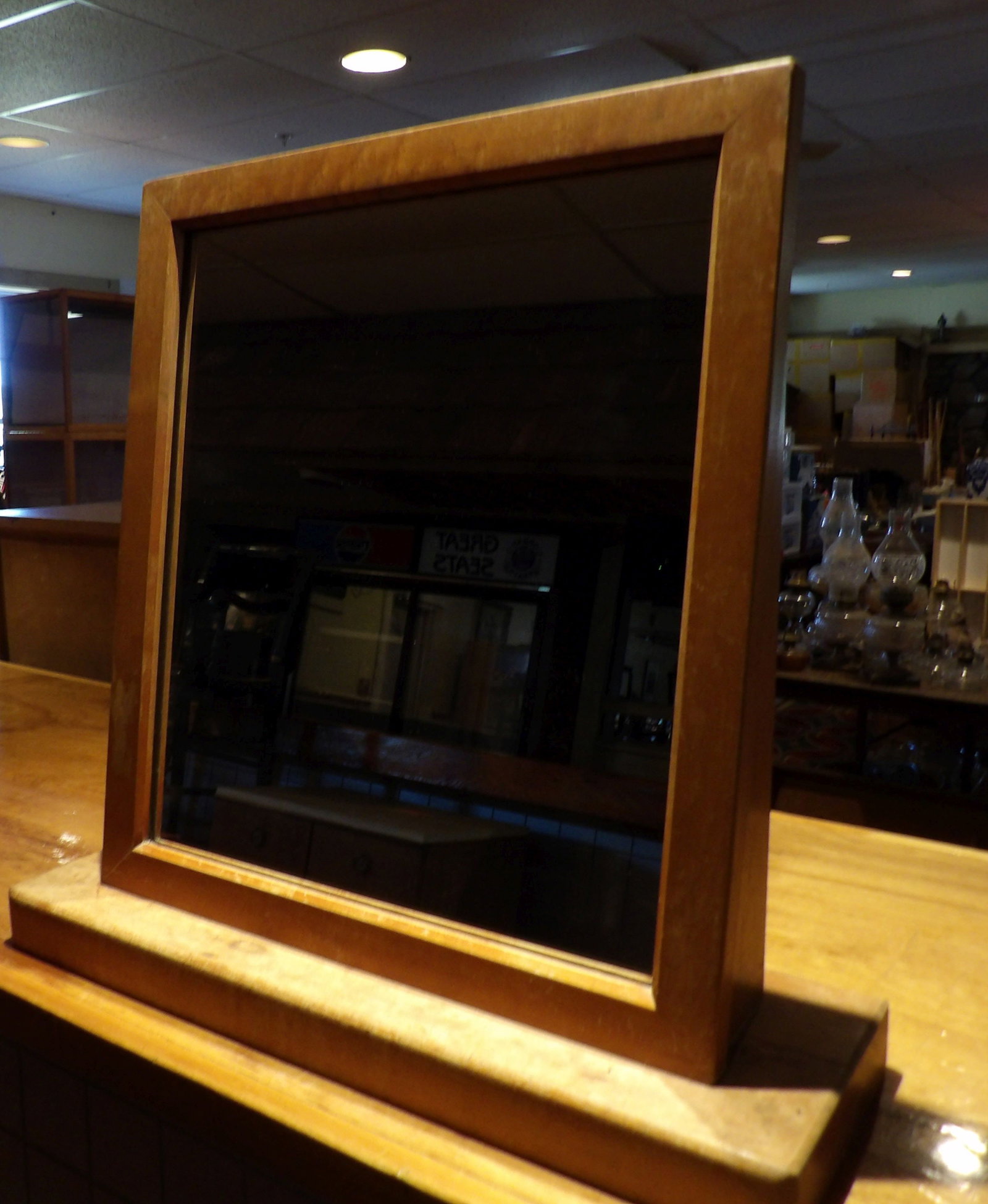 Rectangular MCM Framed Vanity Mirror: Rectangular MCM Framed Vanity Mirror with Wooden Stand. 18" X 20". All measurements approximate. Please see photos for condition and details. Selling as is from 04281.