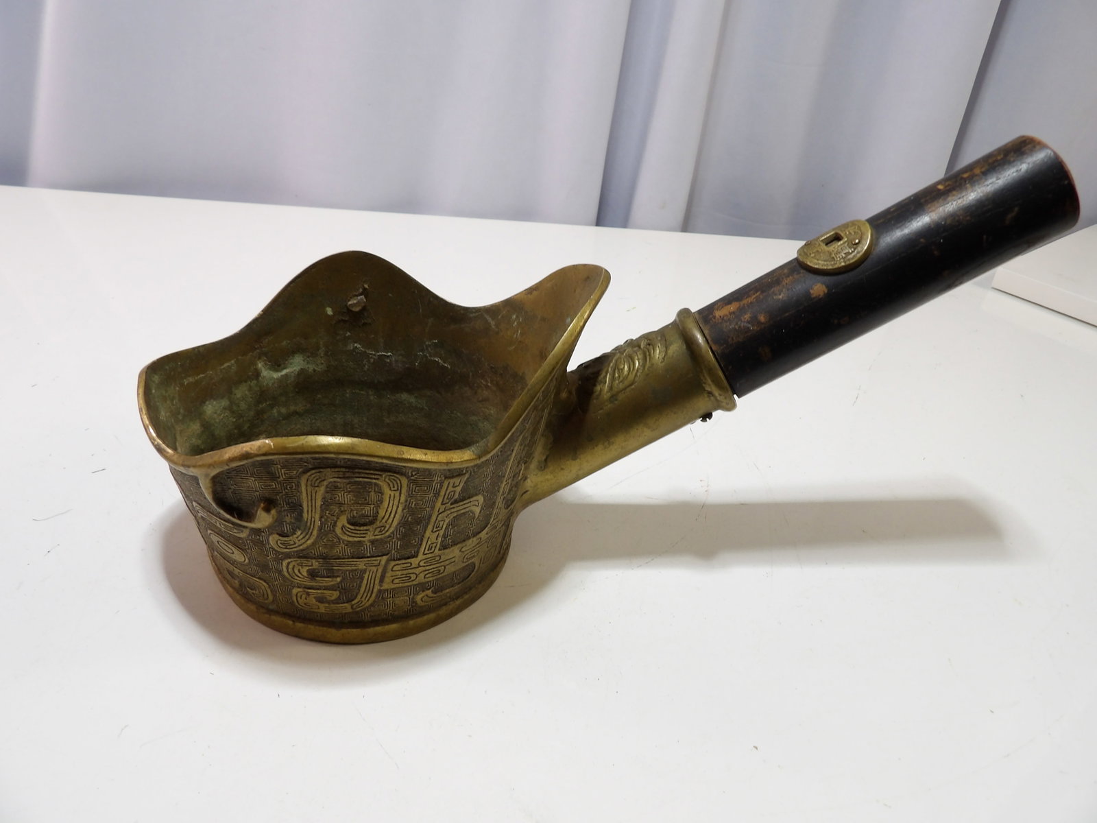 Chinese Brass Silk Iron: Vintage Chinese Brass Silk Iron with Black Wooden Handle and Coin Detail. All measurements approximate. Please see photos for condition and details. Selling as is from 04281.