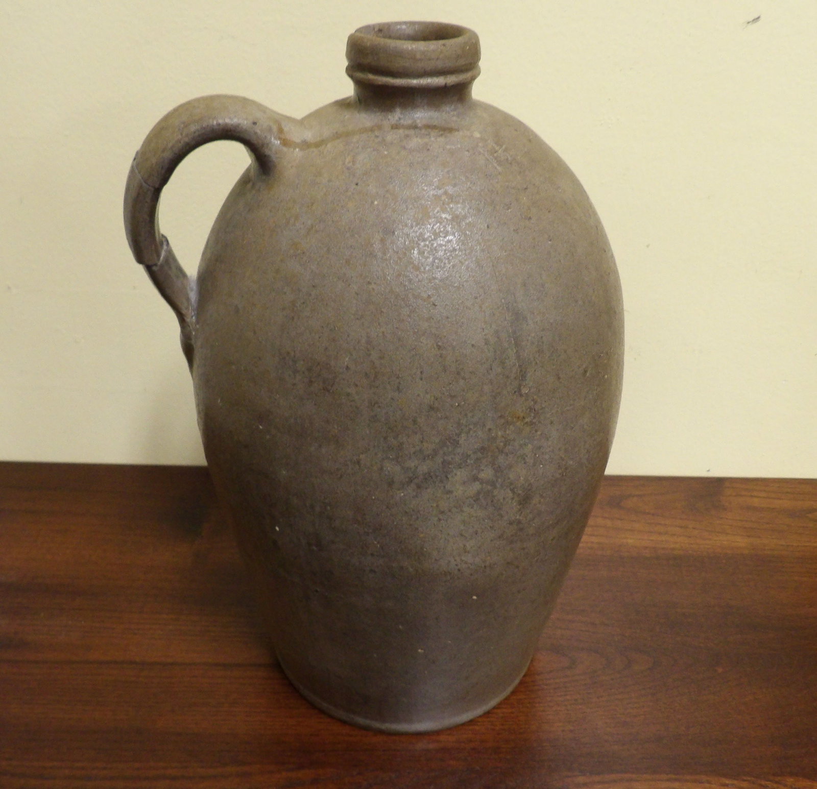 Antique Single Handle Stoneware Glazed Jug: Primitive Antique Single Handle Stoneware Glazed Jug. (Handle has been repaired.) All measurements approximate. Please see photos for condition and details. Selling as is from 04281.