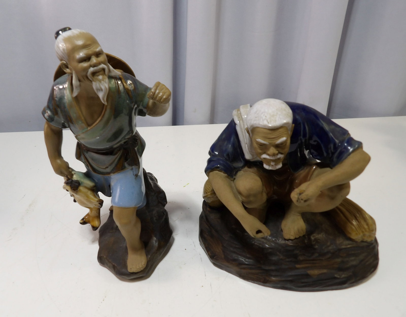 Pair of Glazed Ceramic Figures: Pair of Glazed Ceramic Figures, Elderly Asian Fisherman. All measurements approximate. Please see photos for condition and details. Selling as is from 04281.