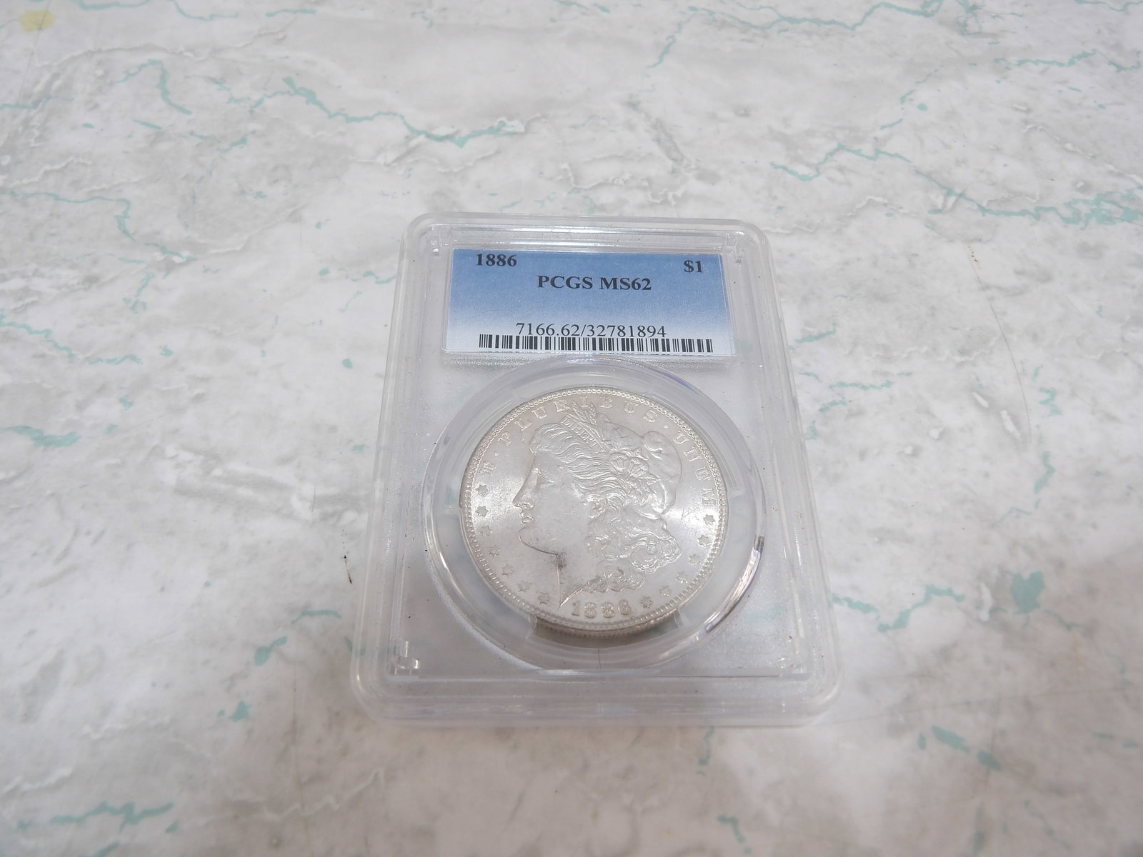 1886 Morgan Silver Dollar: 1886 Morgan Silver Dollar, PCGS MS62. All measurements approximate. Please see photos for condition and details. Selling as is from 04281.