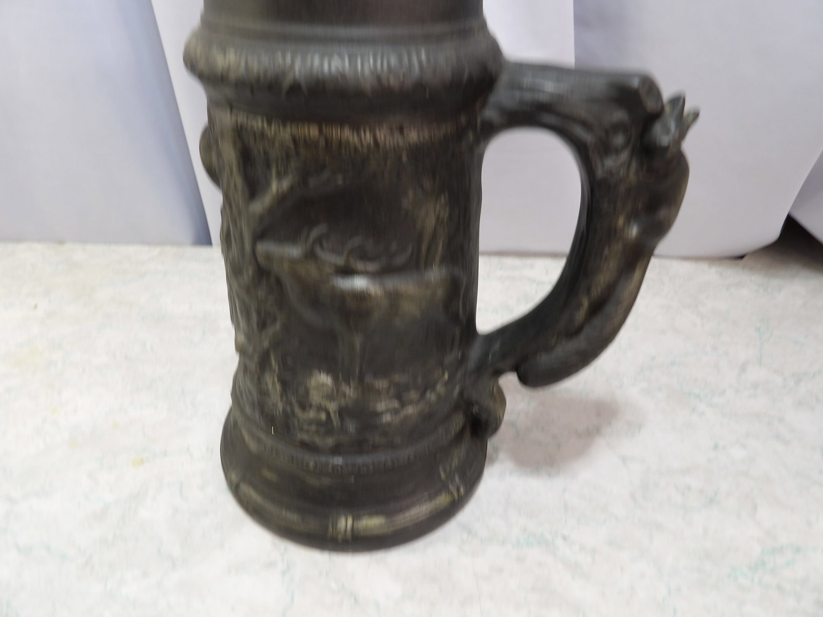 Ceramic Beer Stein with Hunting Scene: Vintage Ceramic Beer Stein with Embossed Deer Hunting Scene and Branch Handle. All measurements approximate. Please see photos for condition and details. Selling as is from 04281.