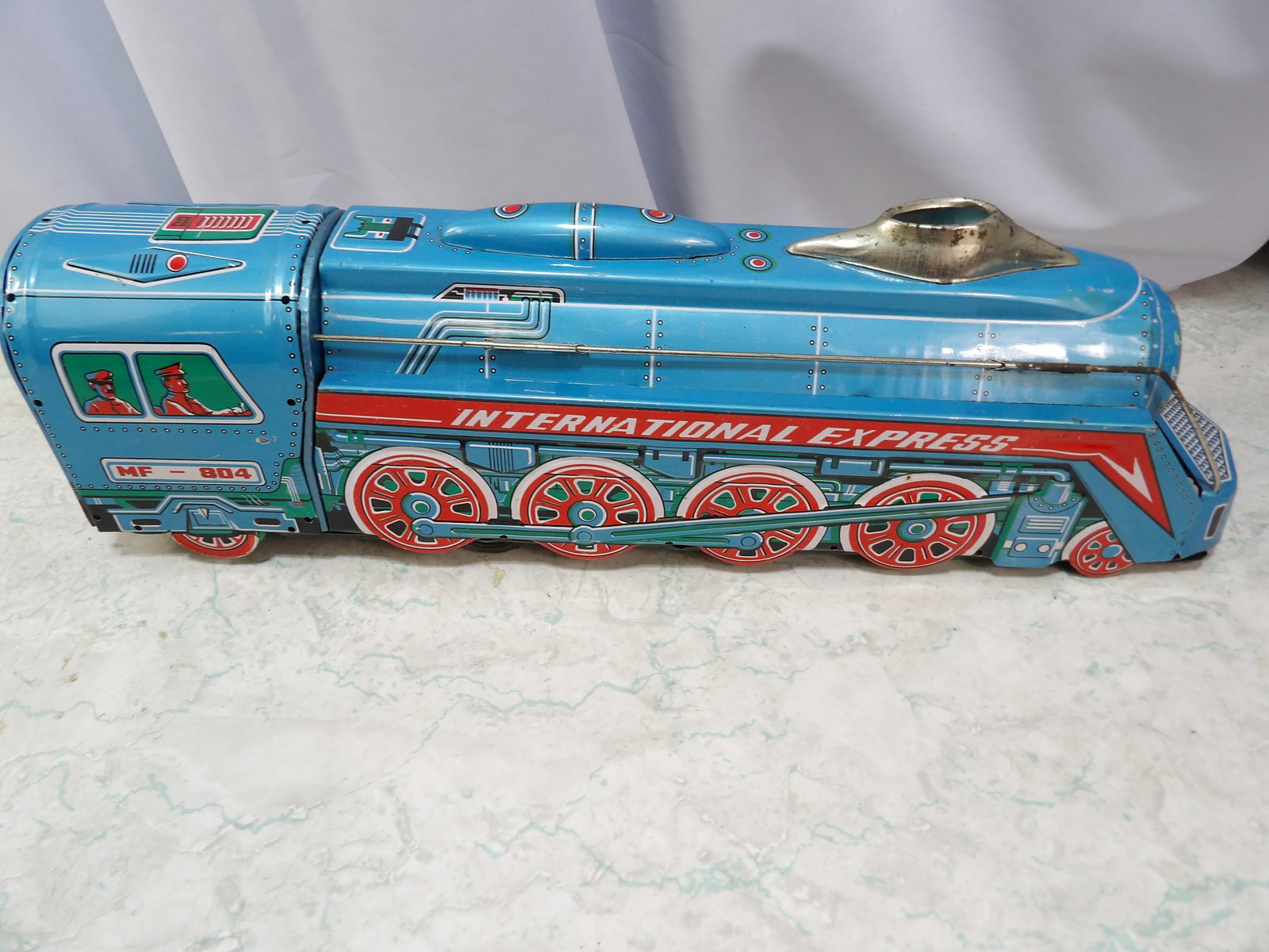 MF 804 International Express Tin Friction Locomotive Toy: Vintage MF 804 International Express Tin Friction Locomotive Toy. Along with LiveShip (handled by LiveAuctioneers), we also can have a local shipper package and ship your purchases. Just choose buyer