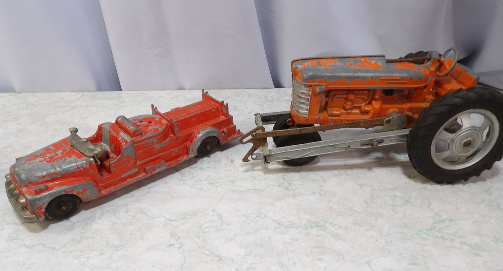 Hubley Tractor and Fire Engine Toy Set: Vintage 1950's Hubley Diecast Orange Tractor and Fire Engine Toy Set. Along with LiveShip (handled by LiveAuctioneers), we also can have a local shipper package and ship your purchases. Just choose