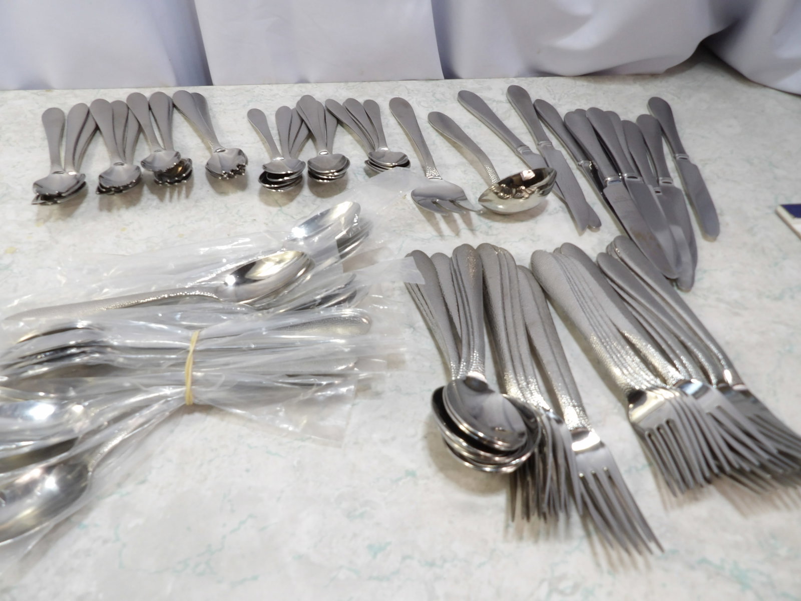 Large Set of Lenox Stainless Steel Flatware: Large Set of Lenox Stainless Steel Flatware with Hammered Handles. Never used. Some still in original plastic. Along with LiveShip (handled by LiveAuctioneers), we also can have a local shipper