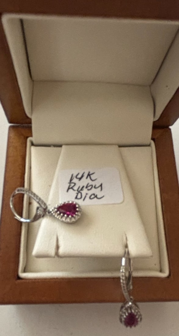 14K Gold Ruby and Diamond Earrings Set: This exquisite jewelry set features a pair of matching dangle earrings, all crafted from 14K gold. The central elements are pear-shaped rubies, each surrounded by a halo of small, sparkling diamonds.