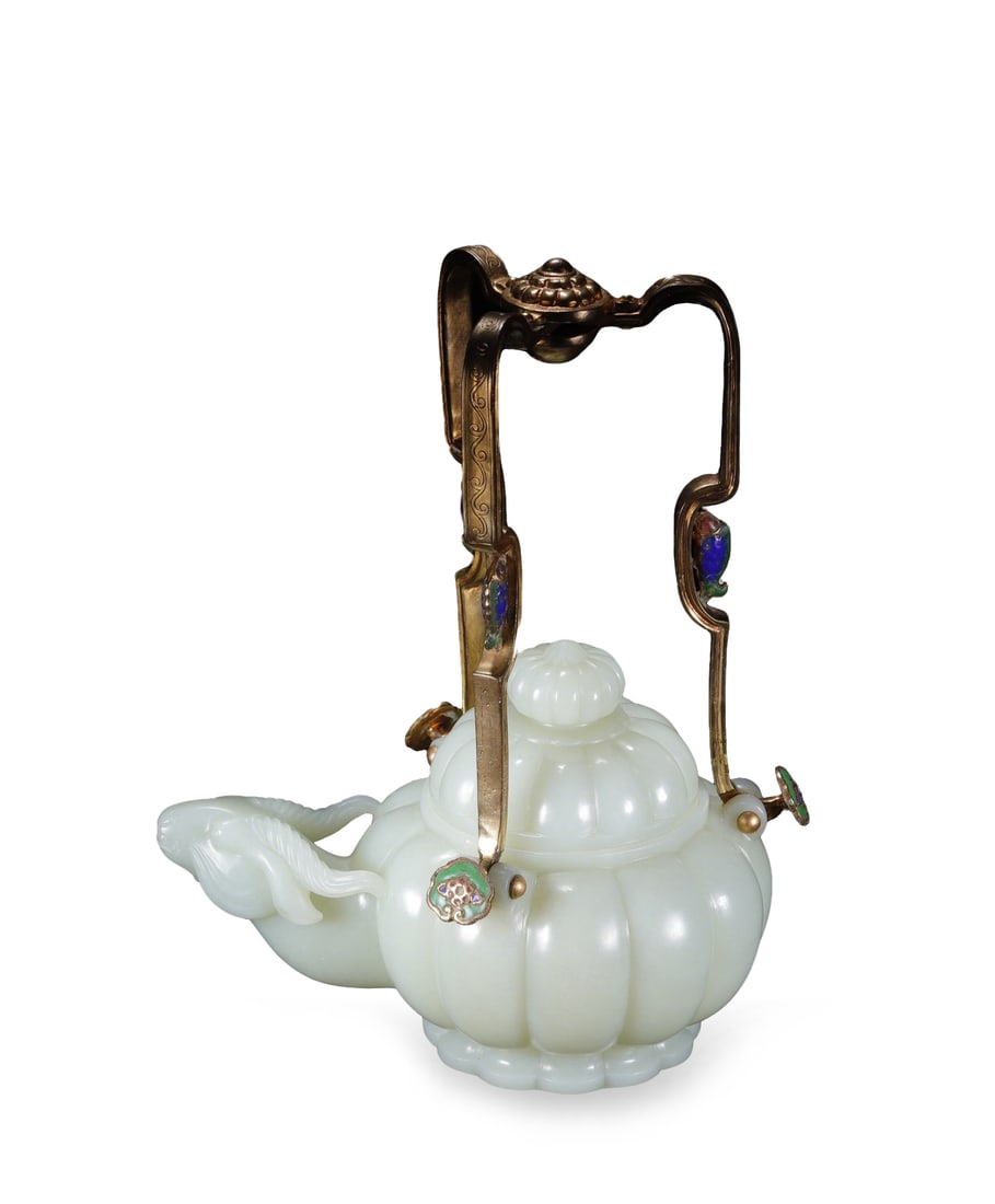 Qing Dynasty Hetian White Jade Melon-Ribbed Goat-Head Ewer with Gilt-Bronze Cloisonné Handle: L:19cm W:12.2cm H:24.5cm Weight:1057.8g This is a Qing Dynasty Hetian white jade melon-ribbed goat-head ewer with gilt-bronze cloisonné handle, an important imperial court jade vessel. The ewer is ca