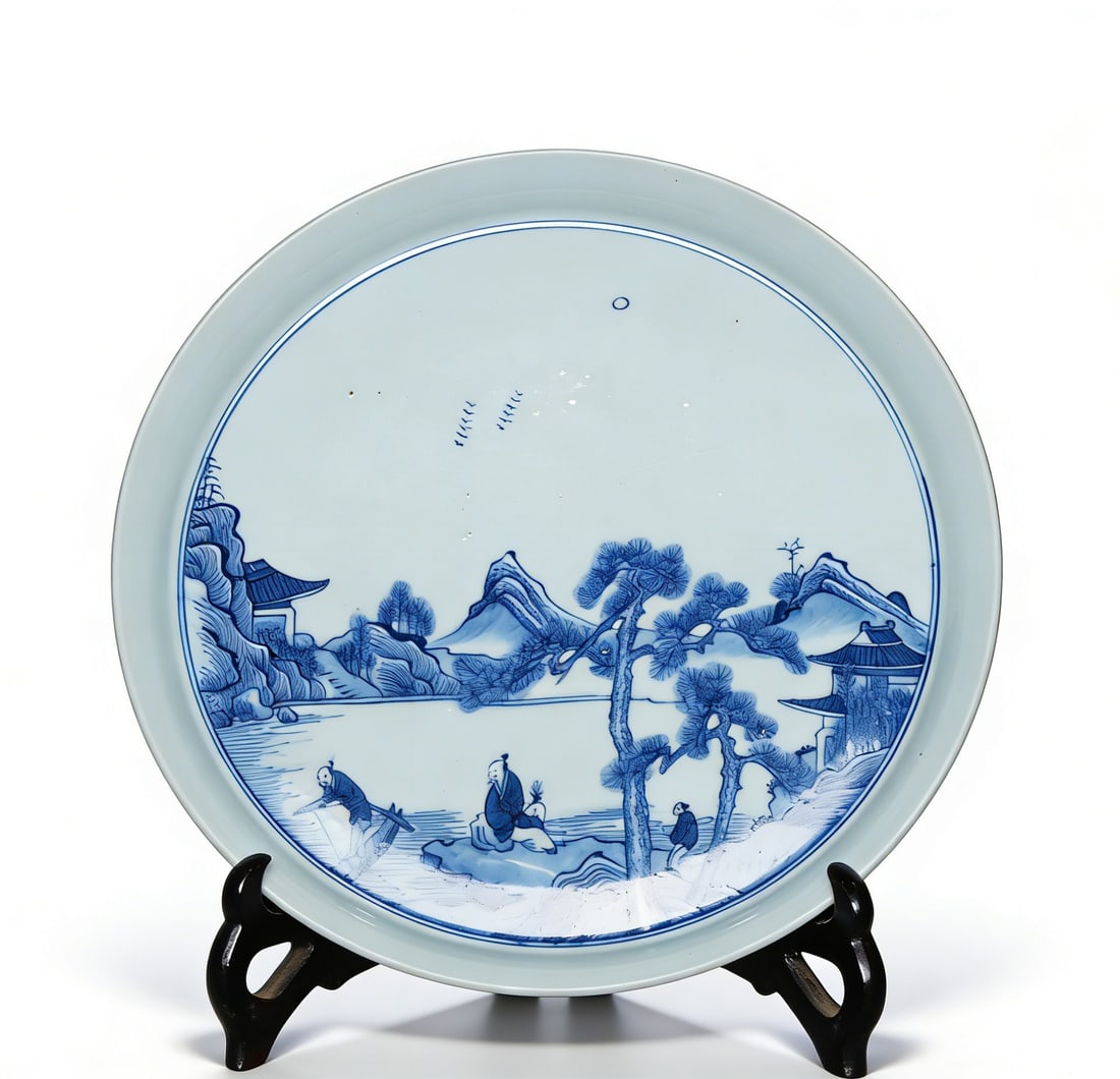 Qing Dynasty Blue-and-White Plate with Landscape and Figure Motifs: H:3.7cmW:26cm This is a Qing Dynasty blue-and-white plate with landscape and figure motifs, a fine blue-and-white daily-use decorative porcelain piece. Shaped with a flared mouth, shallow belly, and r